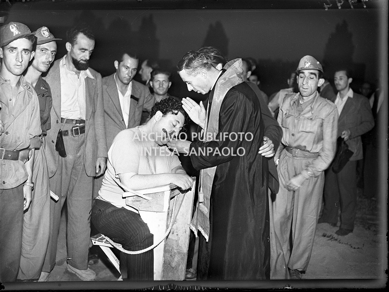 Un sacerdote impartisce la benedizione a Guido Buffarini Guidi prima dell'esecuzione capitale presso il campo sportivo "Giuriati" a Milano