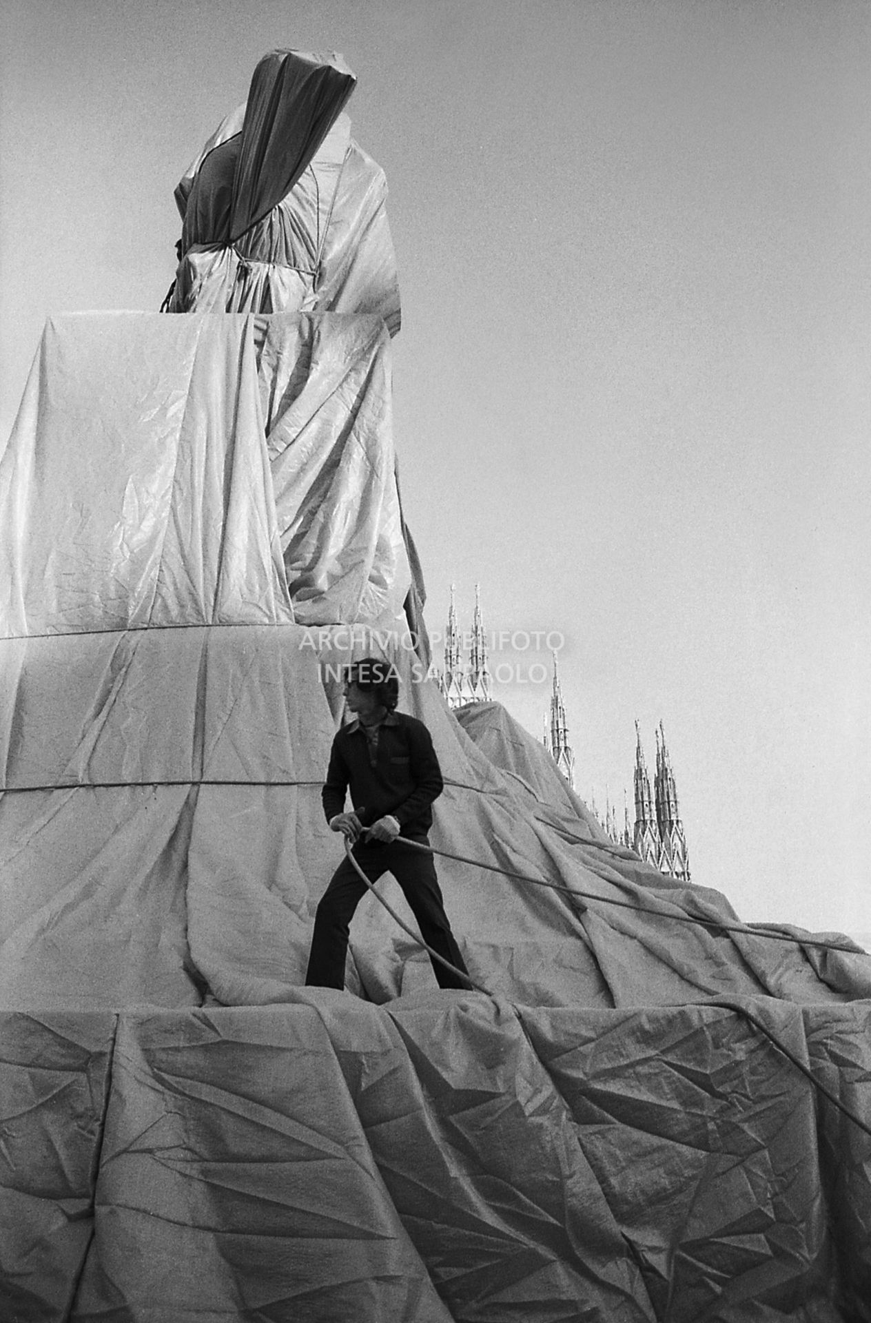 L'artista Christo mentre impacchetta la statua equestre di Re Vittorio Emanuele II in piazza del Duomo a Milano<br>732653/158