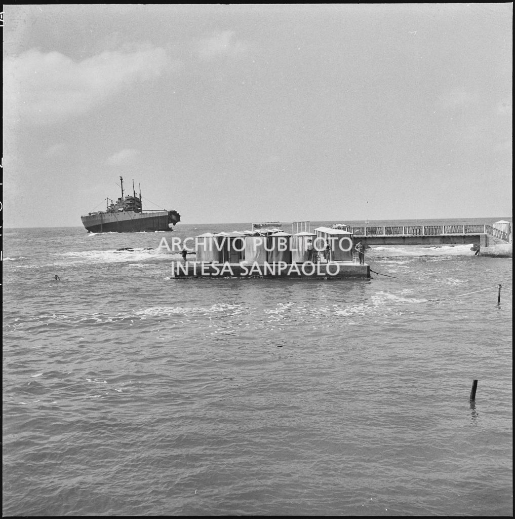 Imbarcazione in navigazione di fronte al lungomare di Livorno e piattaforma con cabine<br>221876