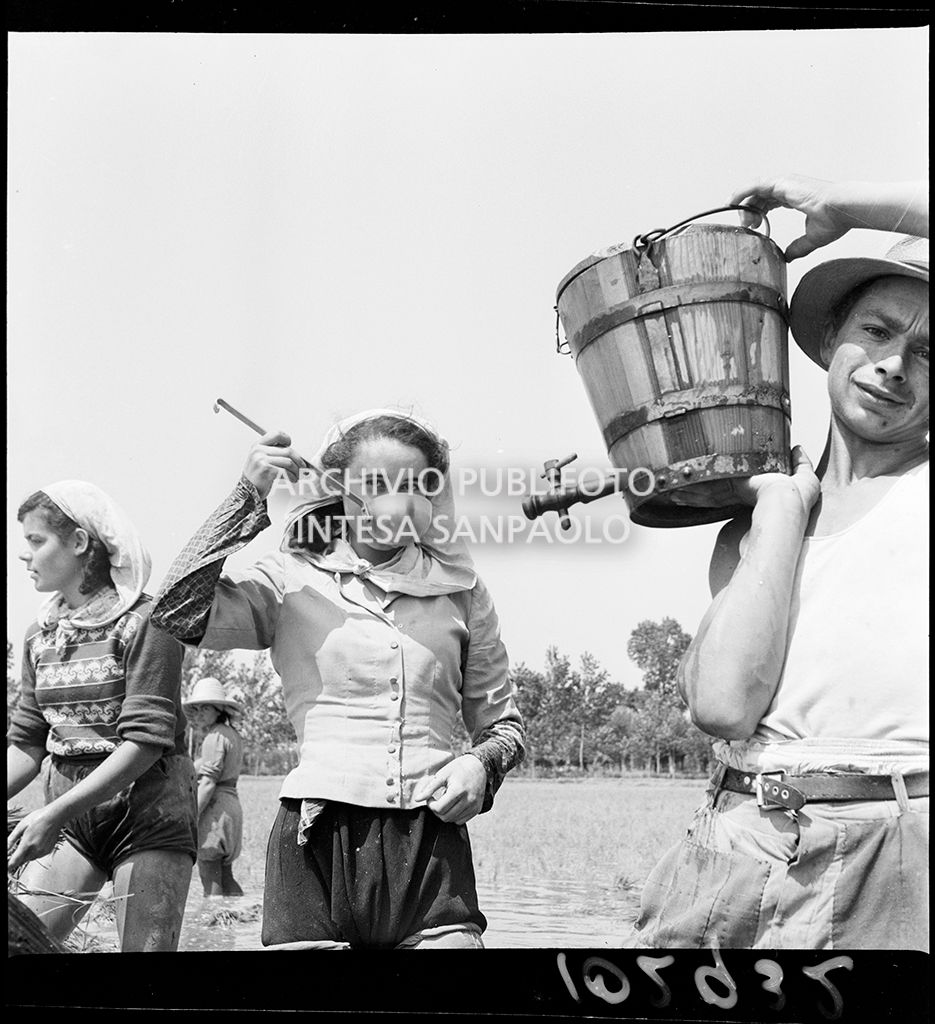 Una mondina al lavoro nei campi nei dintorni di Binasco si disseta