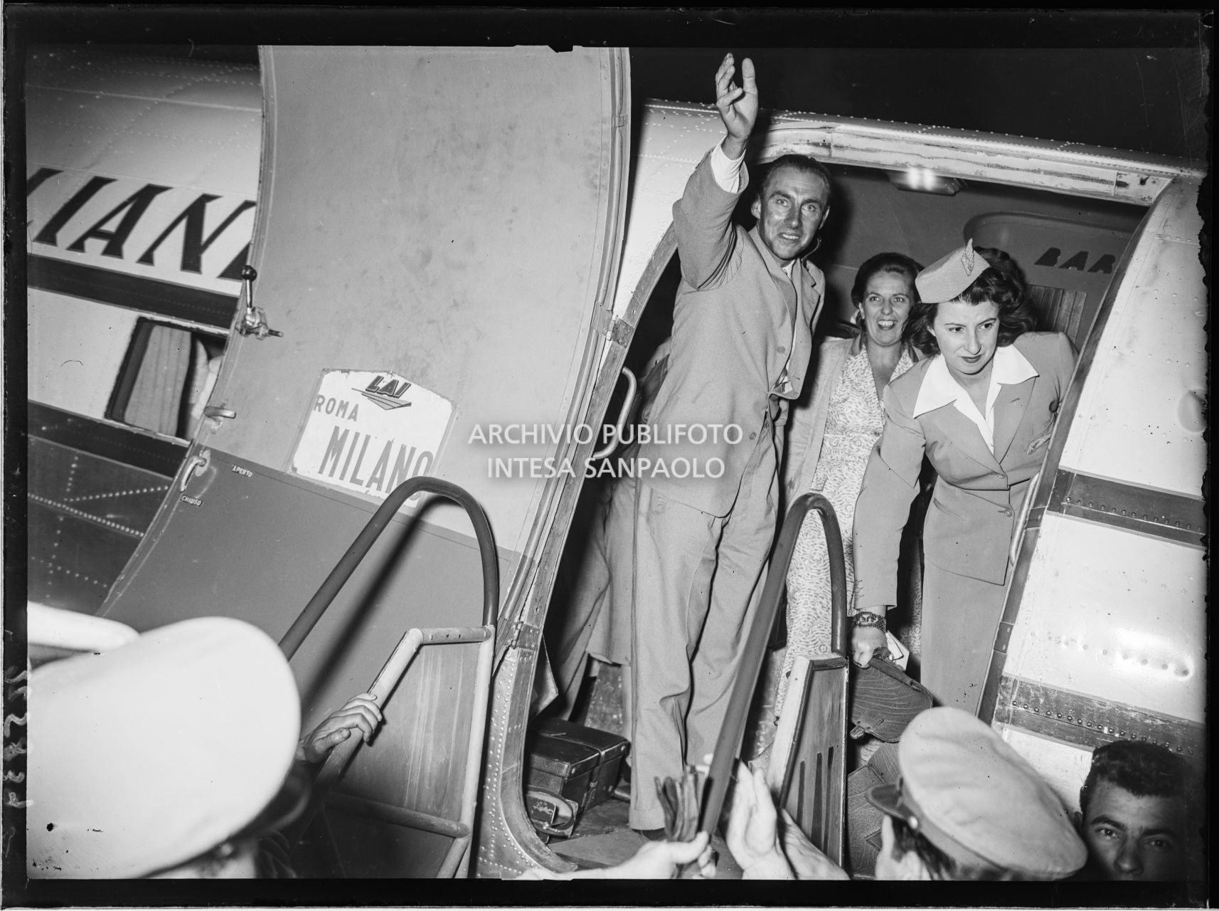 Ubaldo Rey saluta la folla in attesa prima di scendere dall'aereo, all'aeroporto Linate a Milano, dove è arrivato in compagnia di Achille Compagnoni, Guido Pagani e Mario Fantin