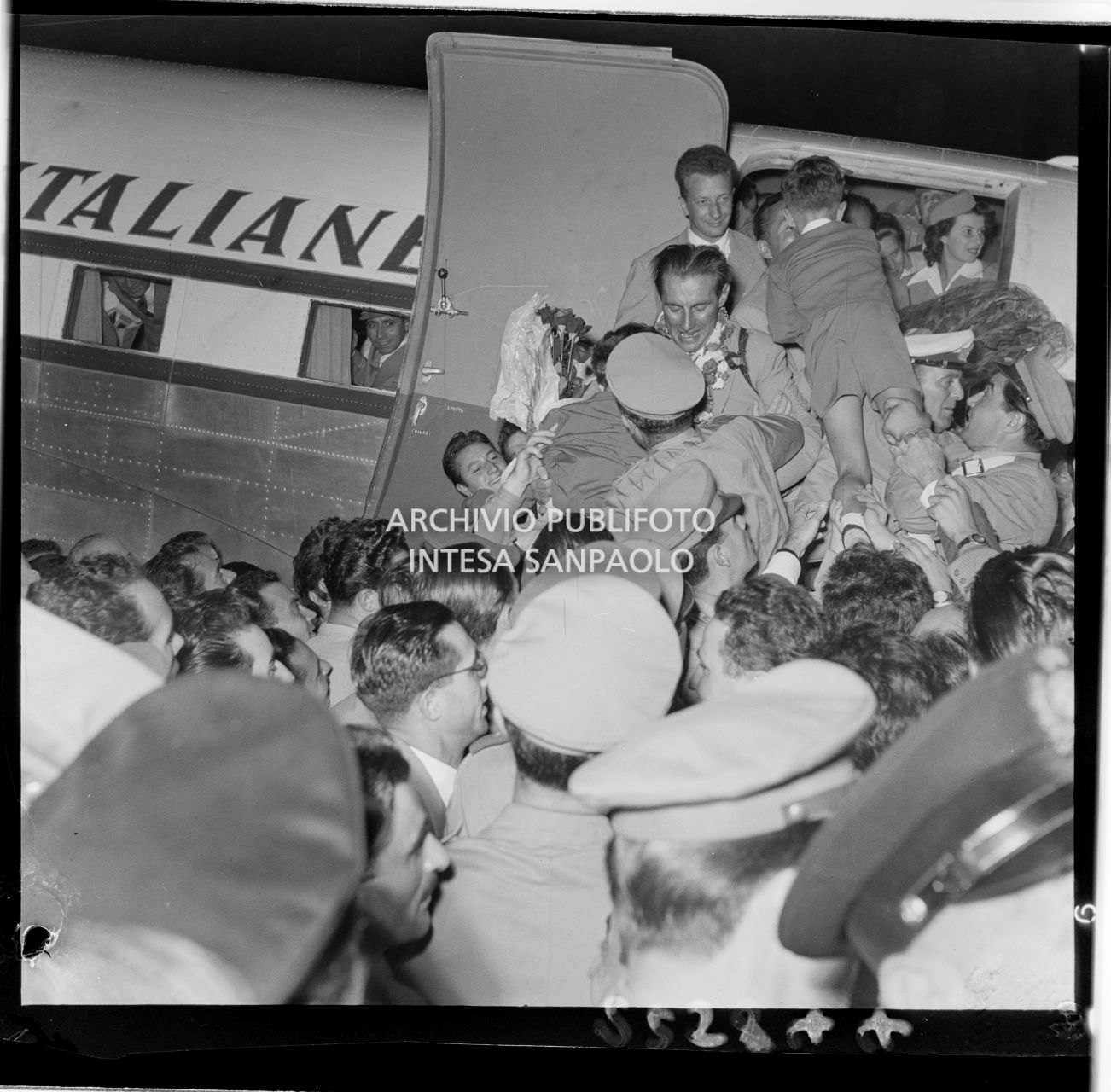 Discesa dall'aereo di Ubaldo Rey e Achille Compagnoni all'aeroporto di Linate a Milano, accolti dalla folla