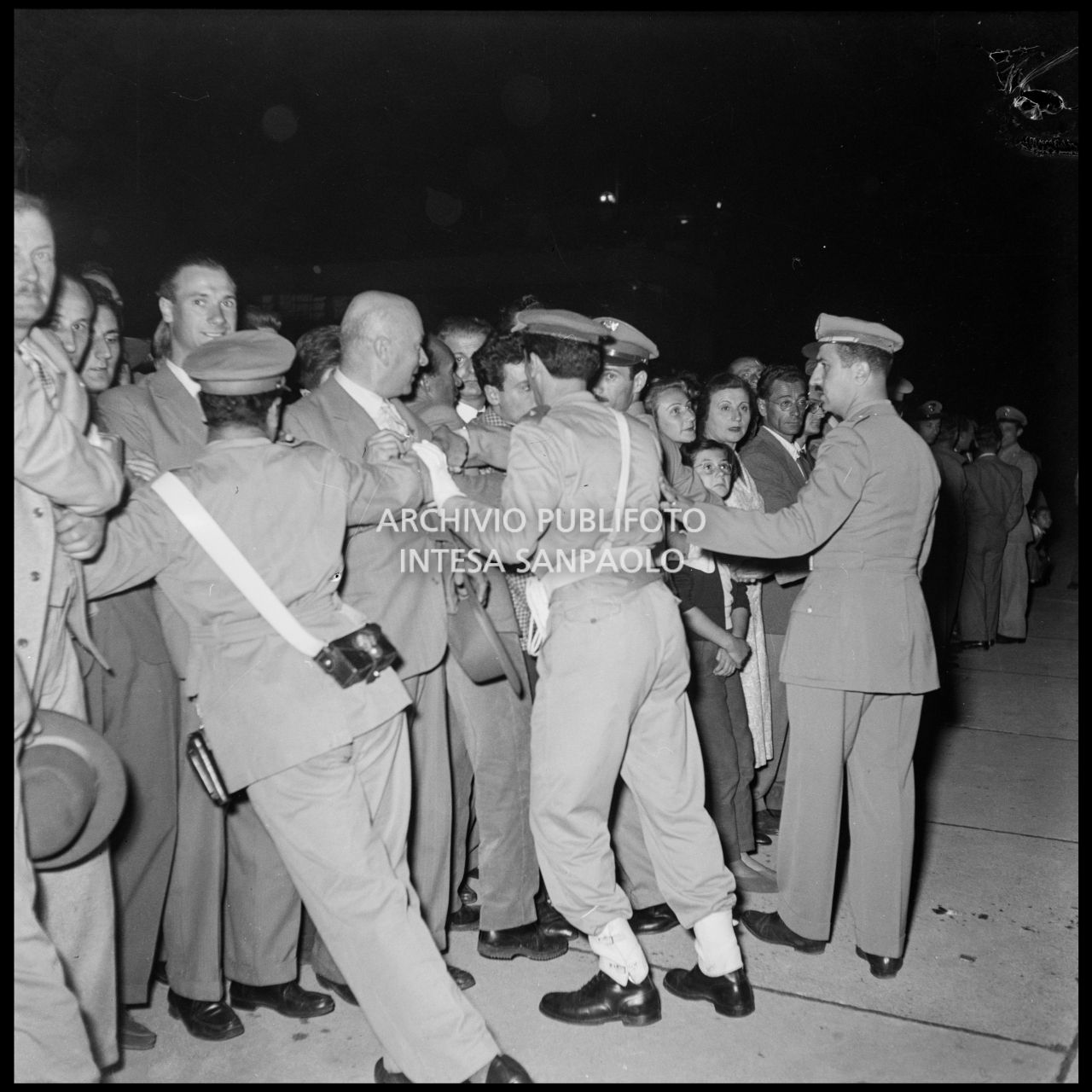 Folla all'aeroporto di Linate a Milano in attesa degli alpinisti di ritorno dalla spedizione sul K2 tenuti a freno dalle forze dell'ordine