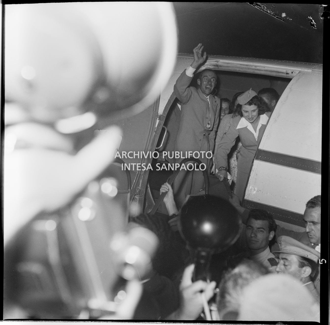 Ubaldo Rey saluta la folla in attesa prima di scendere dall'aereo, all'aeroporto Linate a Milano, dove è arrivato in compagnia di Achille Compagnoni, Guido Pagani e Mario Fantin