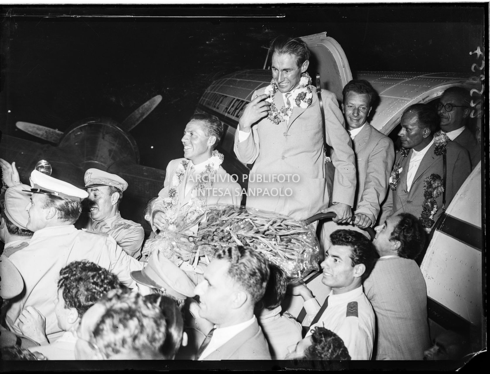 Arrivo di Achille Compagnoni, Ubaldo Rey, Mario Fantini e Guido Pagan all'aeroporto Linate a Milano accolti dalla folla
