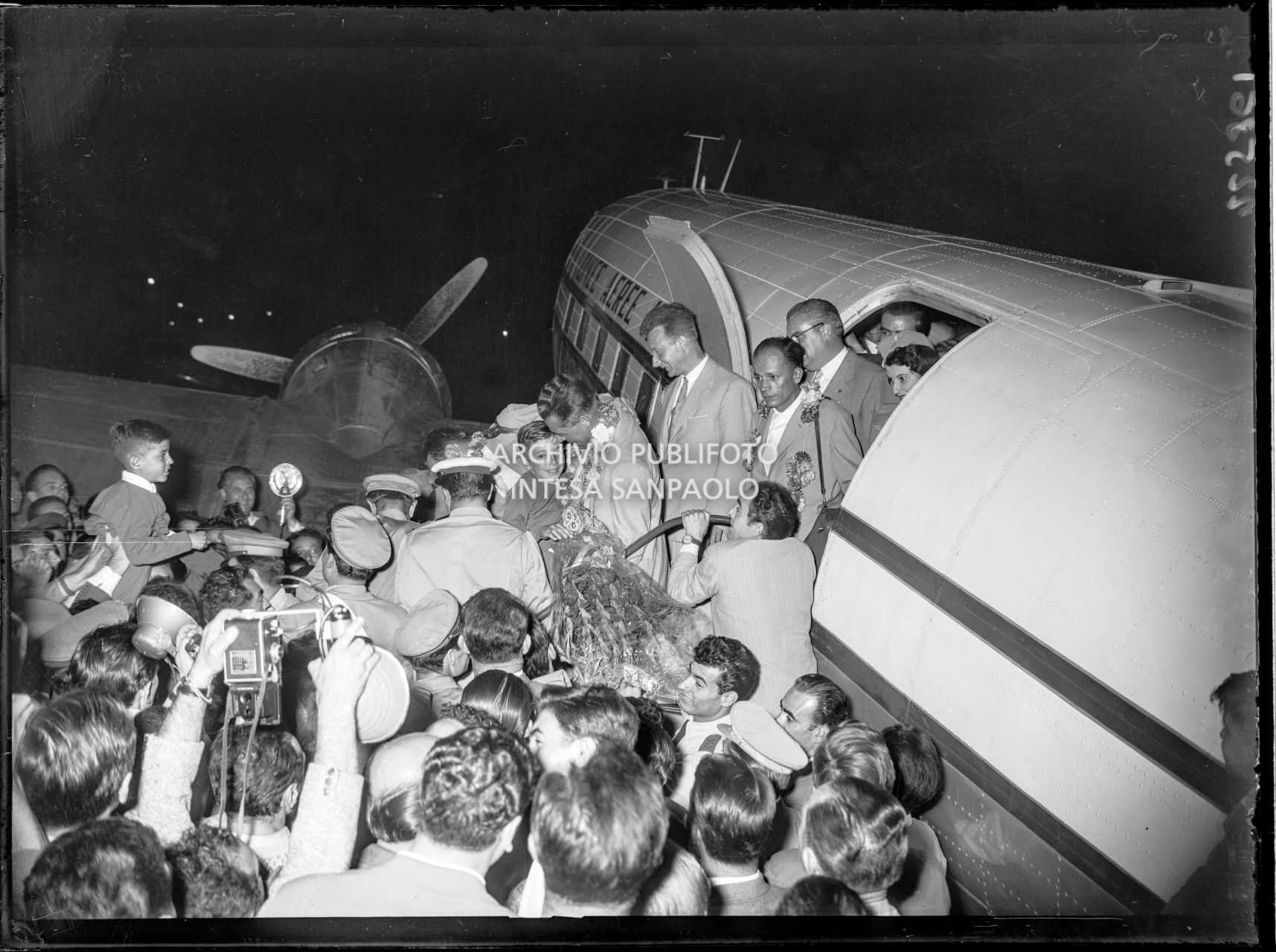 Arrivo di Achille Compagnoni, Ubaldo Rey, Mario Fantini e Guido Pagan all'aeroporto Linate a Milano accolti dalla folla