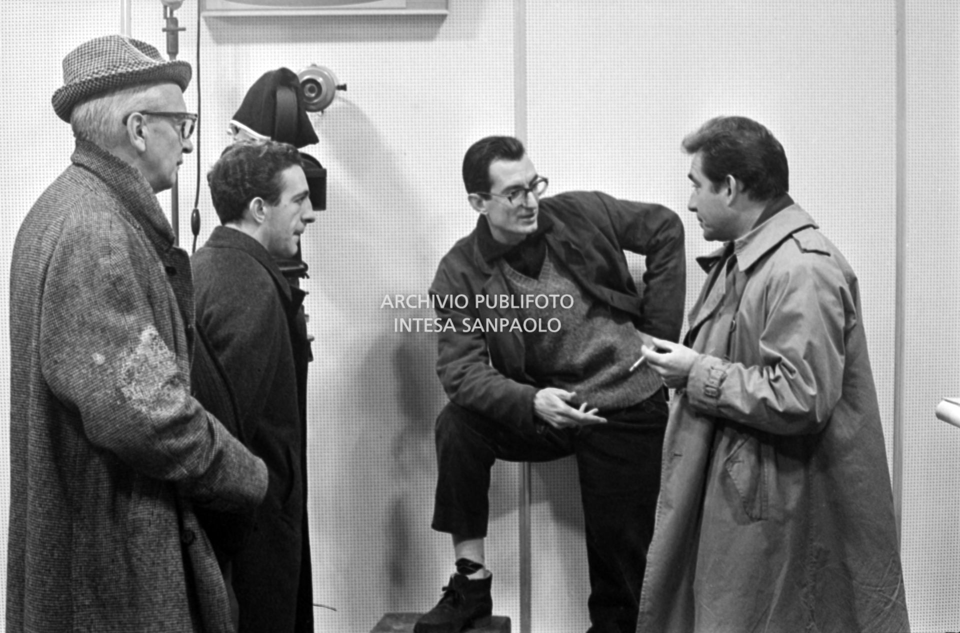 Il regista Carlo Lizzani parla con Ugo Tognazzi sul set del film "La vita agra" alla Fiera Campionaria a Milano