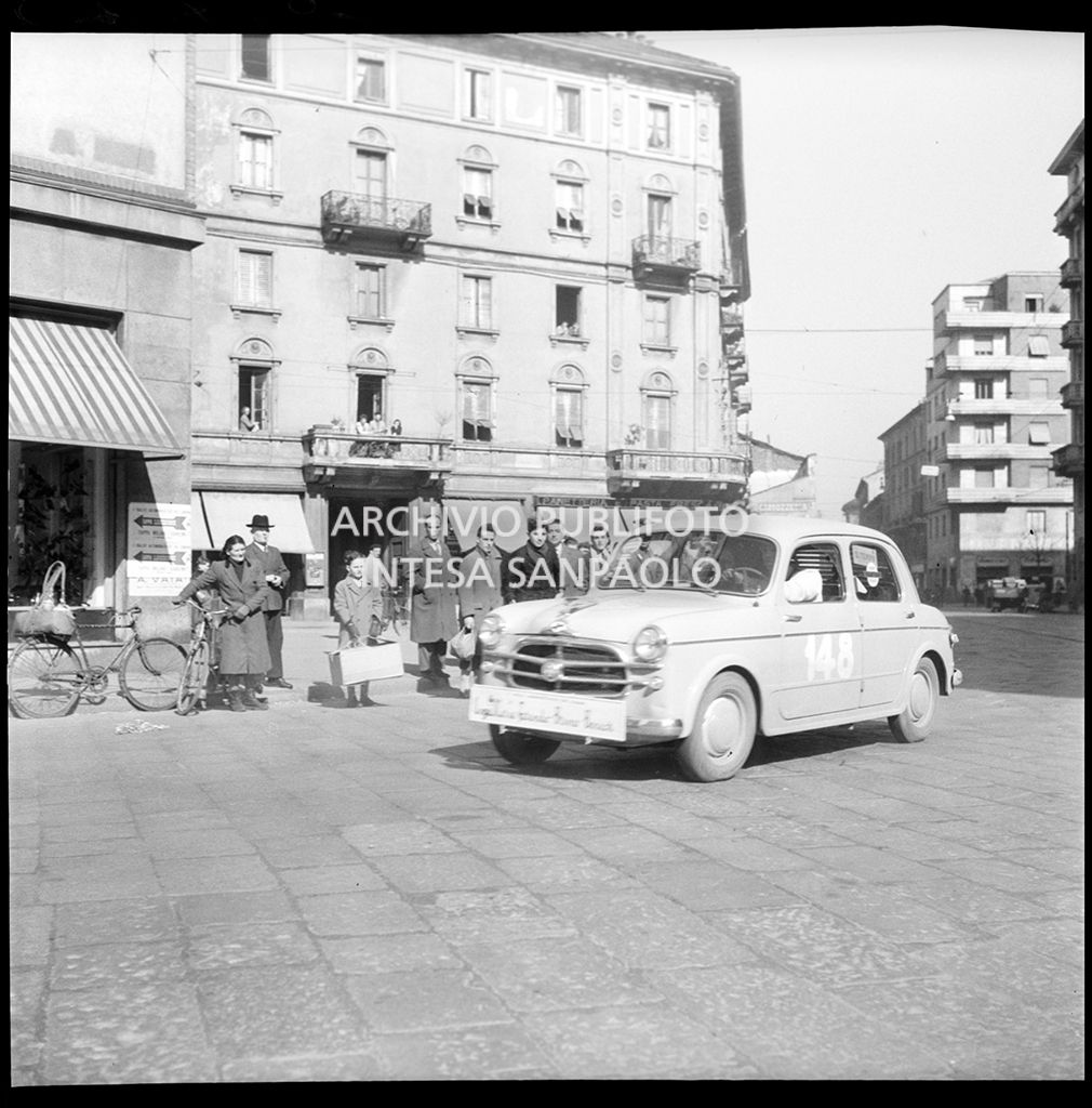 Una Fiat 1100 103, con il numero 148, corre la tappa Milano-Sanremo, per le vie di Milano, del 1° Rallye automobilistico del cinema
