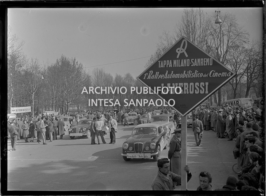 Partenza della tappa Milano-Sanremo del 1° Rallye automobilistico del cinema promosso da Lanerossi; a destra la Lancia Aurelia 2000 con cui gareggiano Maresa Gallo e Paolo Dola