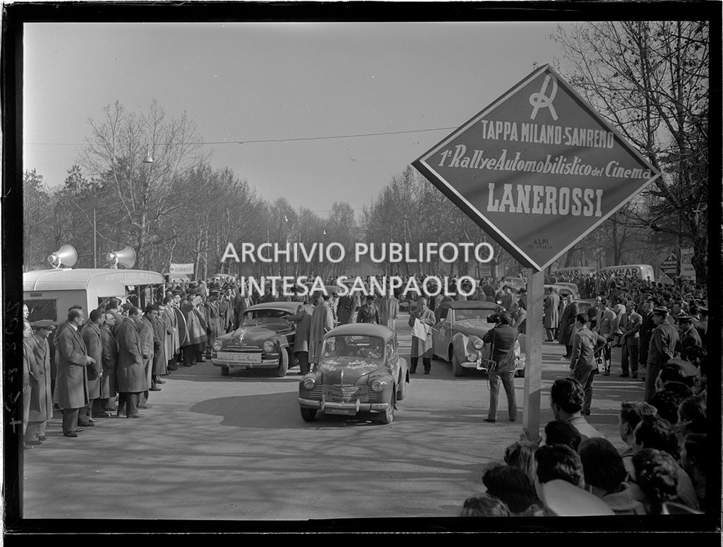 Partenza della tappa Milano-Sanremo del 1° Rallye automobilistico del cinema promosso da Lanerossi; in primo piano il cartello della tappa