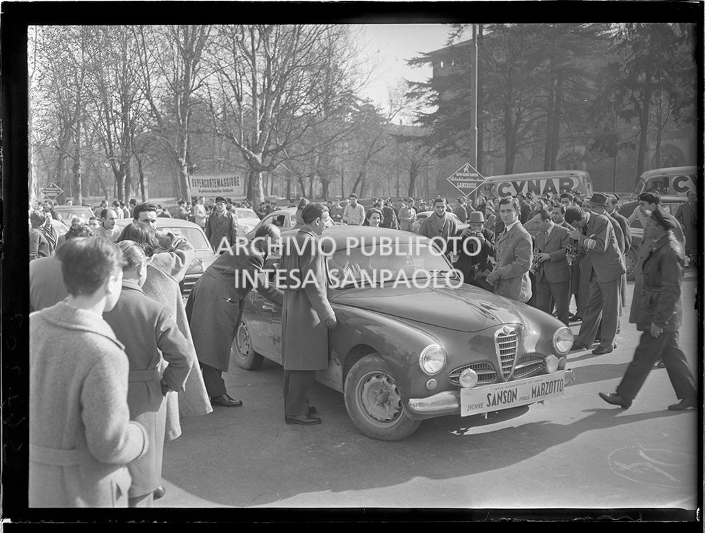 Partenza della tappa Milano-Sanremo del 1° Rallye automobilistico del cinema promosso da Lanerossi; in primo piano la Alfa Romeo 1900 con a bordo Yvonne Sanson e accanto all'auto, in piedi a destra, Paolo Marzotto