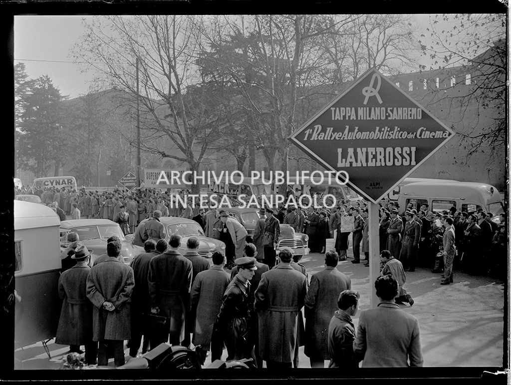 Partenza della tappa Milano-Sanremo del 1° Rallye automobilistico del cinema promosso da Lanerossi; in primo piano il cartello della tappa
