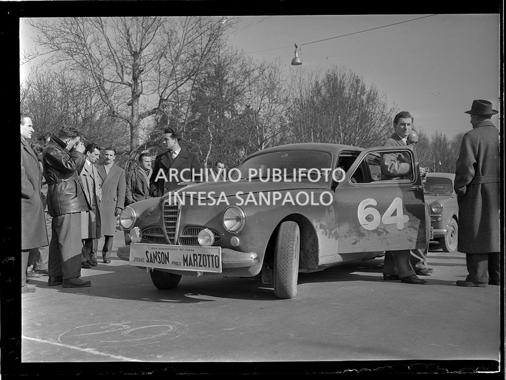 Partenza della tappa Milano-Sanremo del 1° Rallye automobilistico del cinema promosso da Lanerossi; in primo piano l'Alfa Romeo 1900 con cui gareggiano Yvonne Sanson e Paolo Marzotto, in piedi a destra
