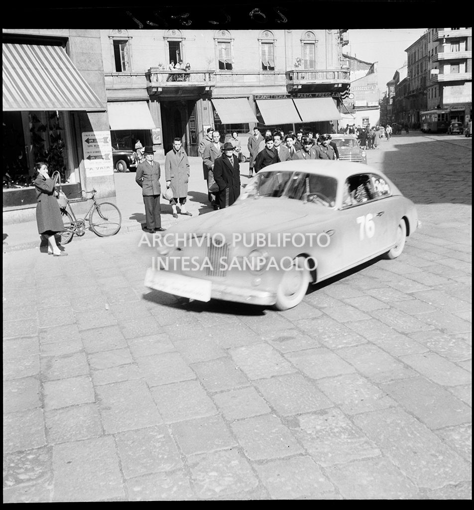 Una Fiat 1400 con il numero 76 corre la tappa Milano-Sanremo, per le vie di Milano, del 1° Rallye automobilistico del cinema