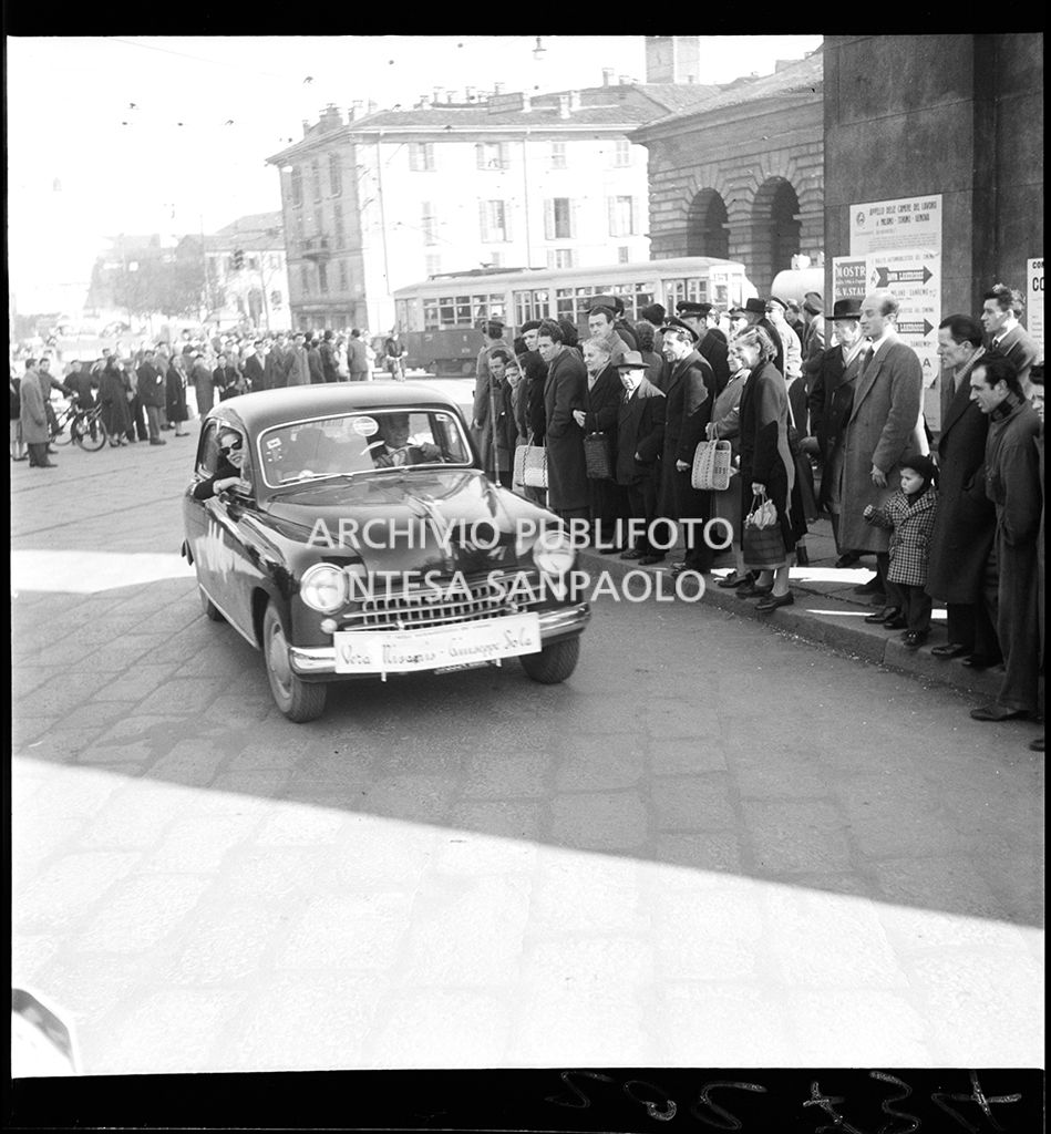 Una Fiat 1400 corre la tappa Milano-Sanremo, per le vie di Milano, del 1° Rallye automobilistico del cinema
