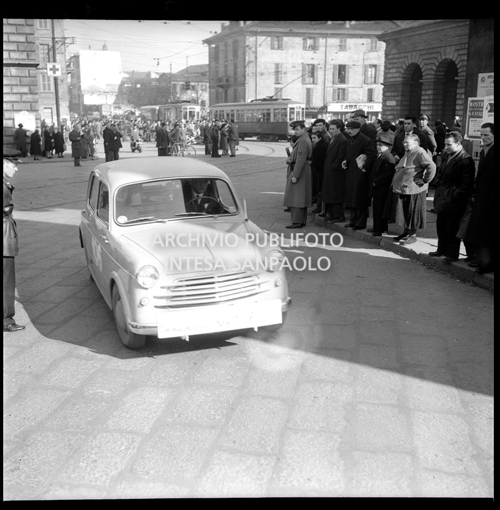 Una Fiat 1100 103, con il numero 106, corre la tappa Milano-Sanremo, per le vie di Milano, del 1° Rallye automobilistico del cinema