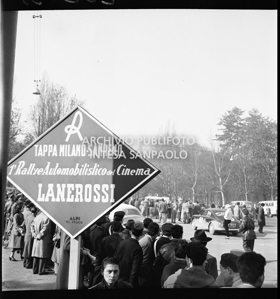 1° Rallye automobilistico del cinema per le vie di Milano: tappa Milano-Sanremo; in primo piano il cartello della tappa