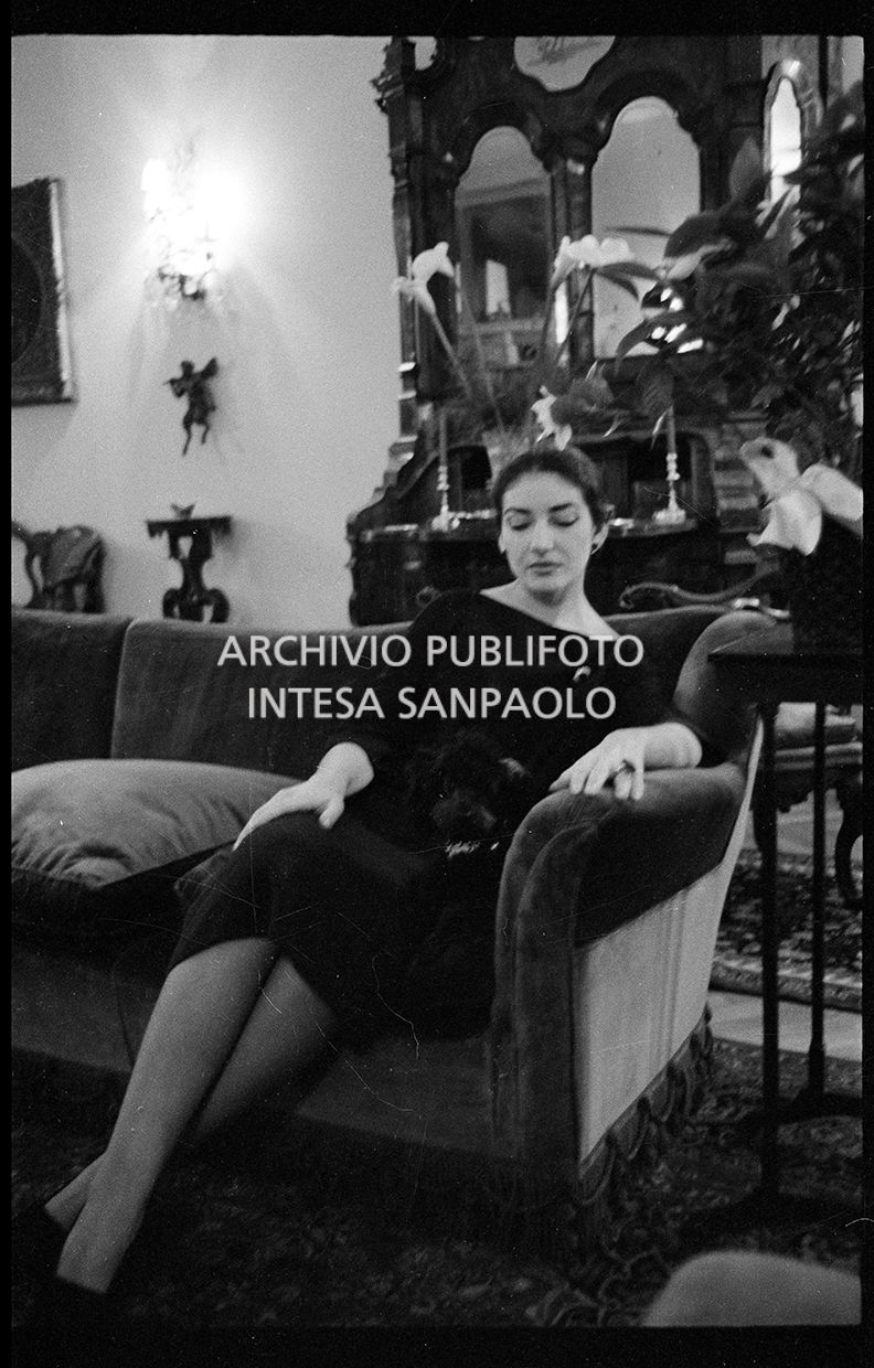 Maria Callas seduta sul divano in compagnia del suo barboncino