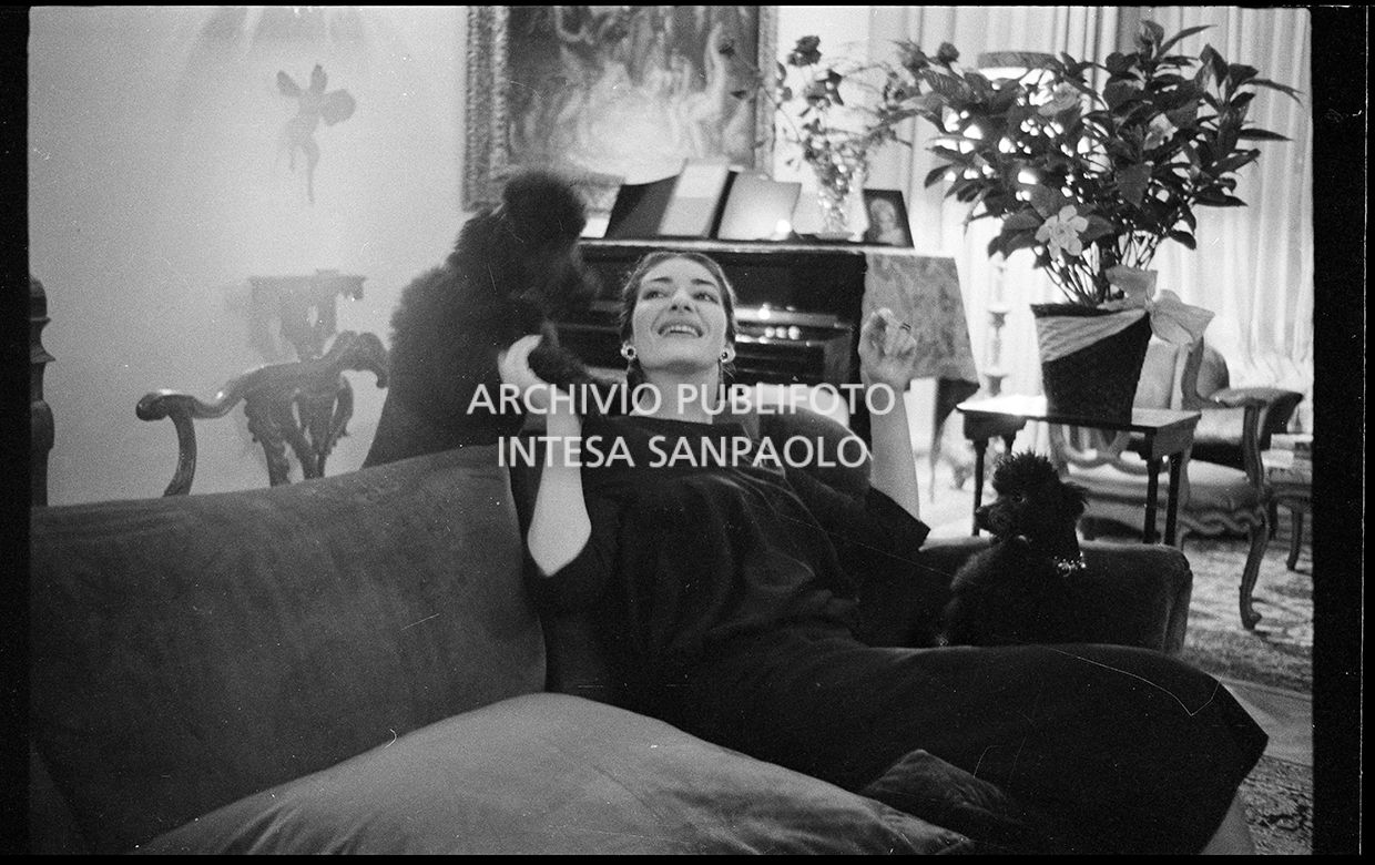 Maria Callas seduta sul divano in compagnia dei suoi barboncini