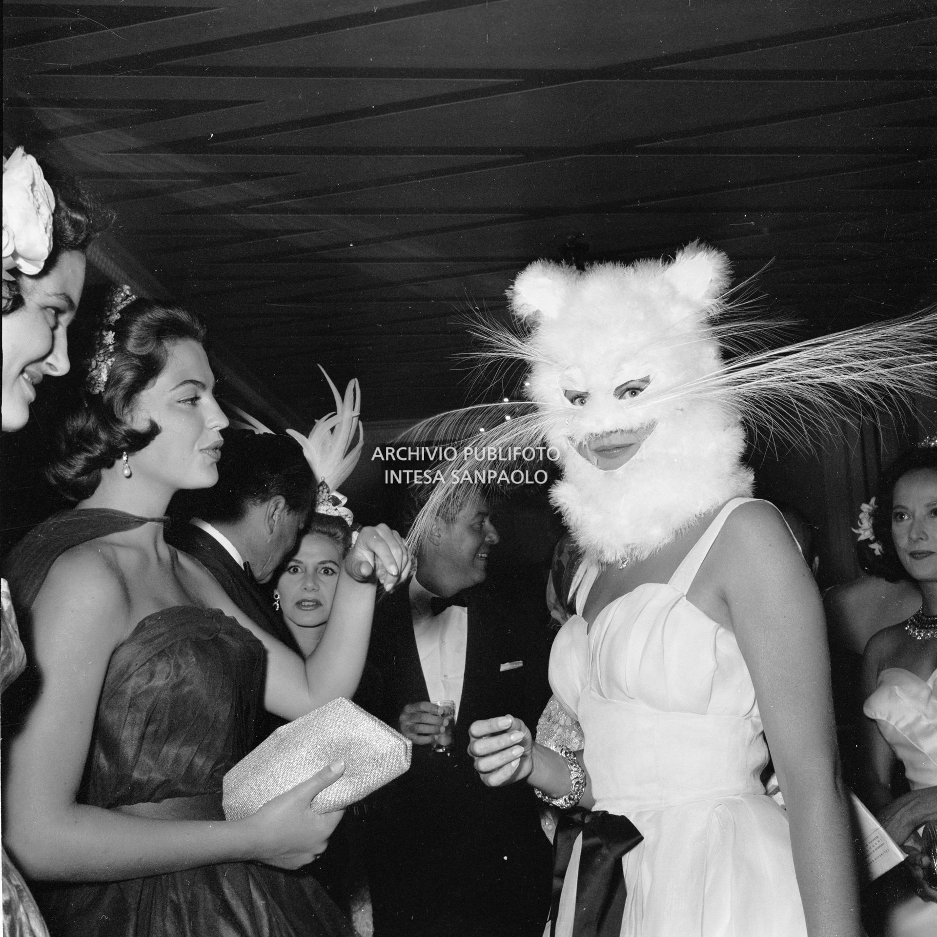 Domitilla Ruspoli, con la maschera da gatto, in compagnia di Ira von Fürstenberg, al ricevimento organizzato da Elsa Maxwell in onore di Maria Callas