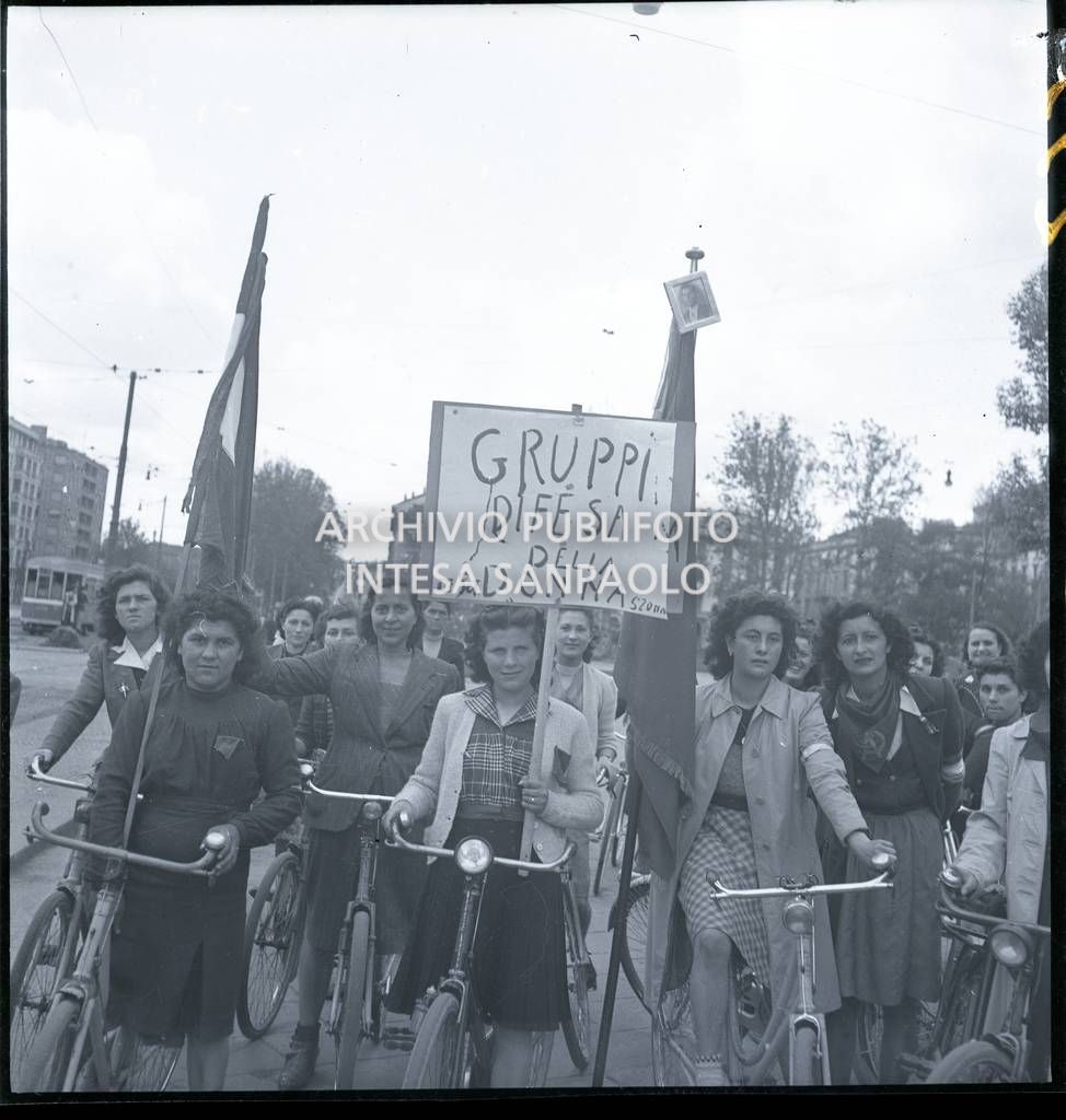 Donne dei Gruppi di difesa della donna (GDD) in bicicletta con bandiere e cartelli