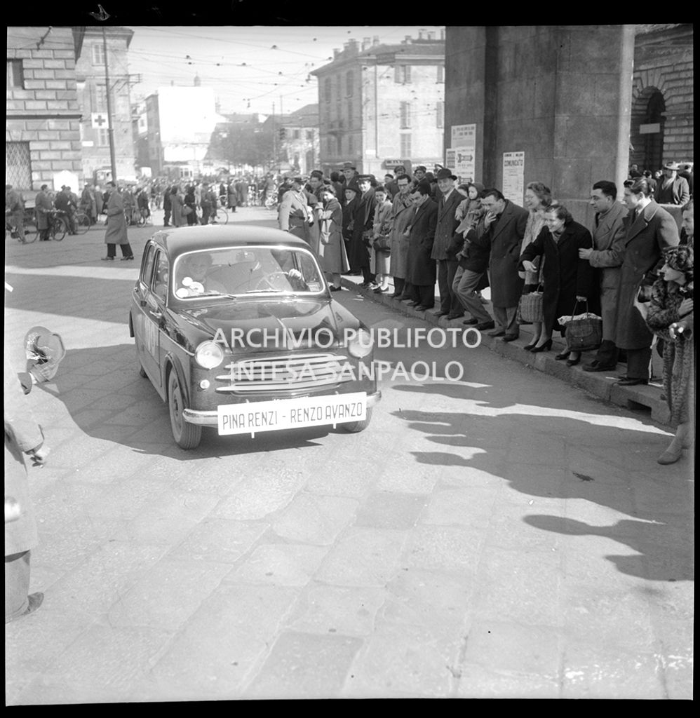 La Fiat 1100 103, con a bordo Pina Renzi e Renzo Avanzo, corre la tappa Milano-Sanremo, per le vie di Milano, del 1° Rallye automobilistico del cinema