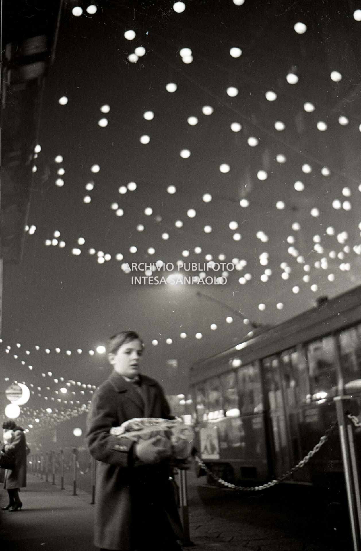 Un ragazzino per le vie di Milano addobbate per il Natale