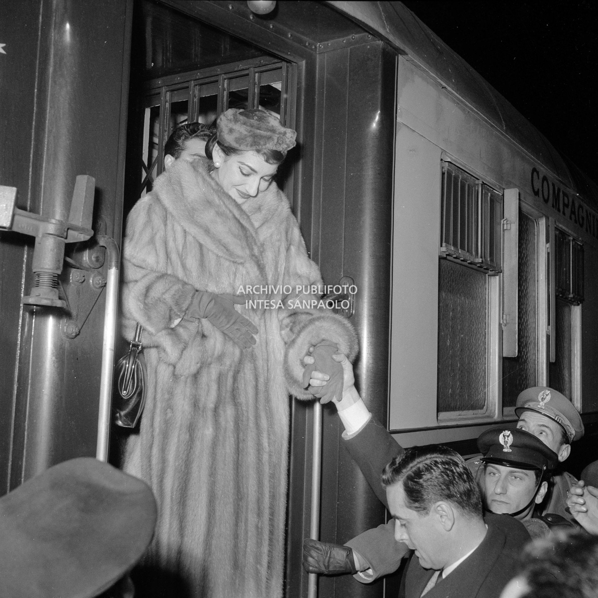 Maria Callas, di rientro da Roma, scende dal treno alla Stazione Centrale di Milano dove una folla di ammiratori la attende