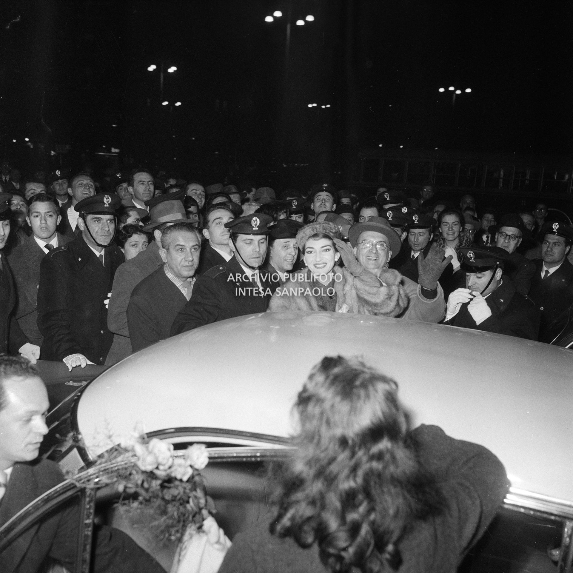 Maria Callas alla Stazione Centrale di Milano, al suo rientro da Roma, si avvia, tra la folla accorsa per accoglierla, all'automobile che la attende