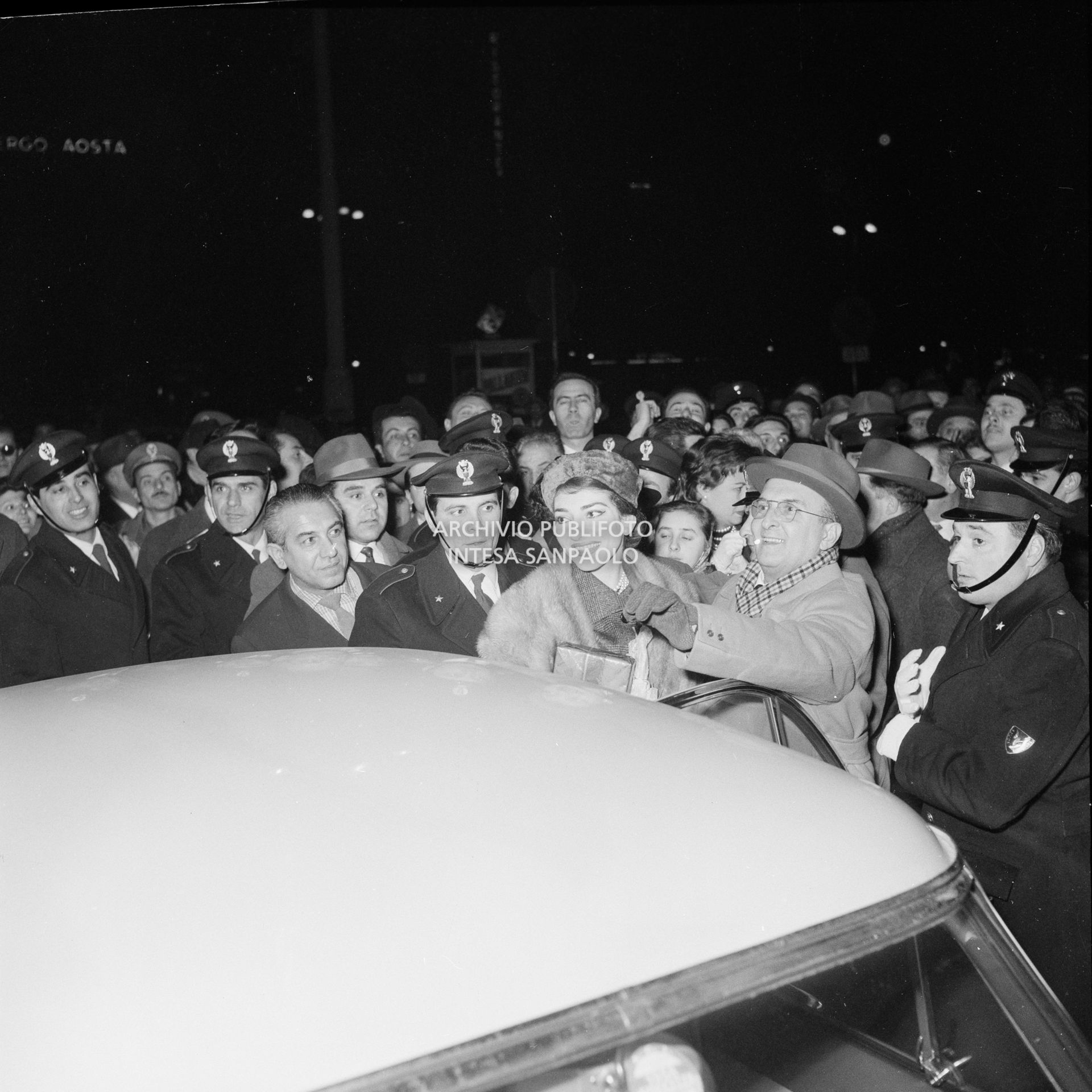 Maria Callas alla Stazione Centrale di Milano, al suo rientro da Roma, si avvia, tra la folla accorsa per accoglierla, a salire sull'automobile che la attende