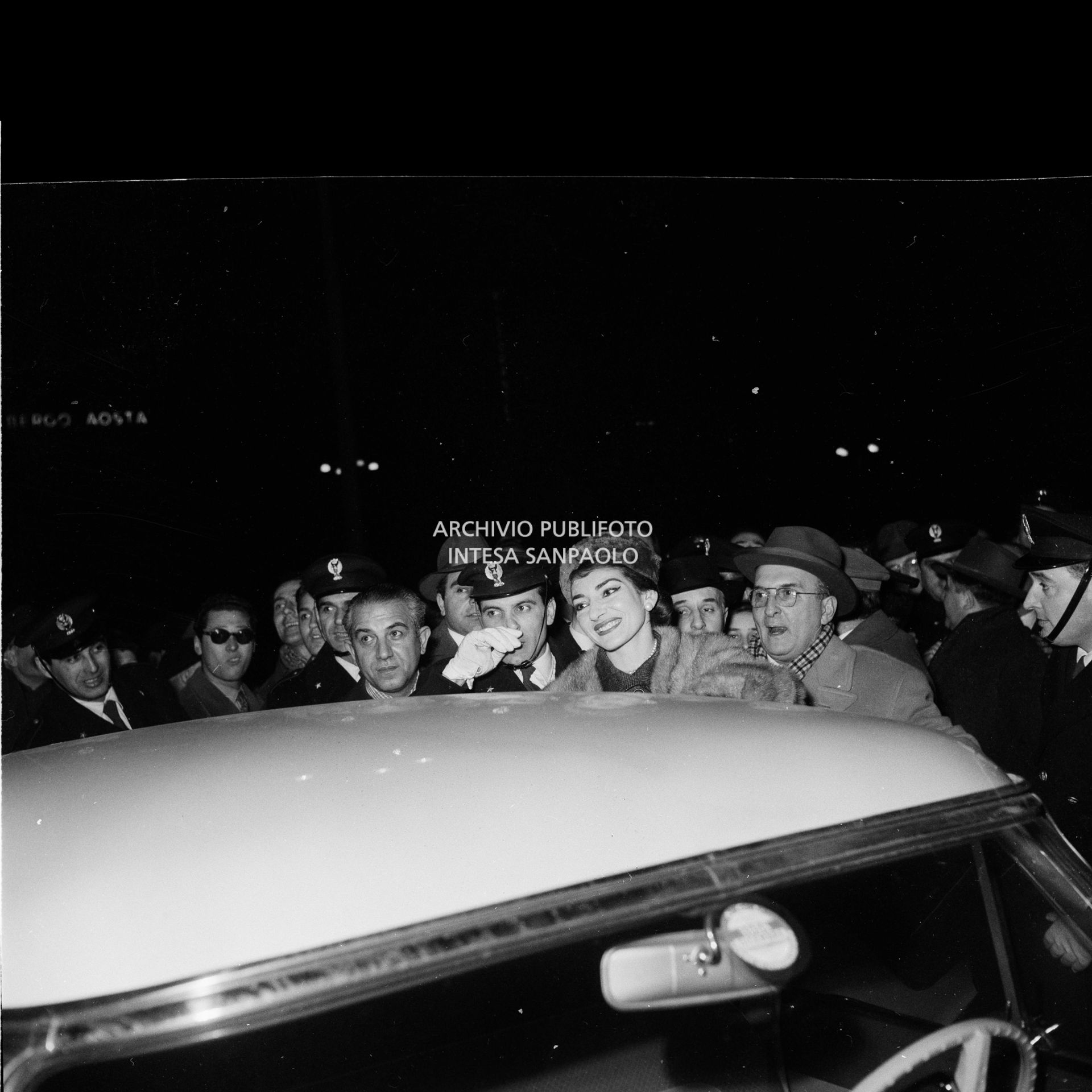 Maria Callas alla Stazione Centrale di Milano, al suo rientro da Roma, si avvia, tra la folla accorsa per accoglierla, a salire sull'automobile che la attende