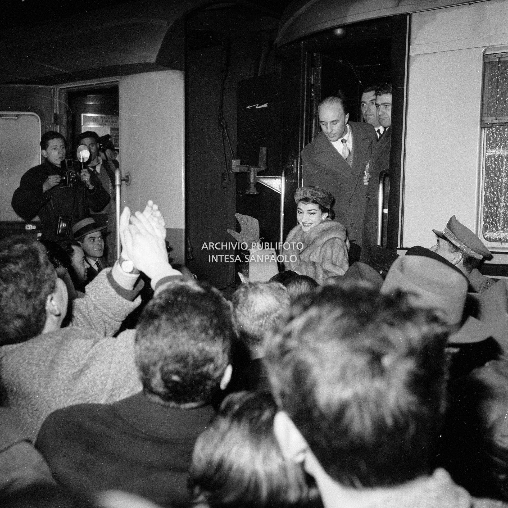 Maria Callas, di rientro da Roma, scende dal treno alla Stazione Centrale di Milano dove una folla di ammiratori la attende
