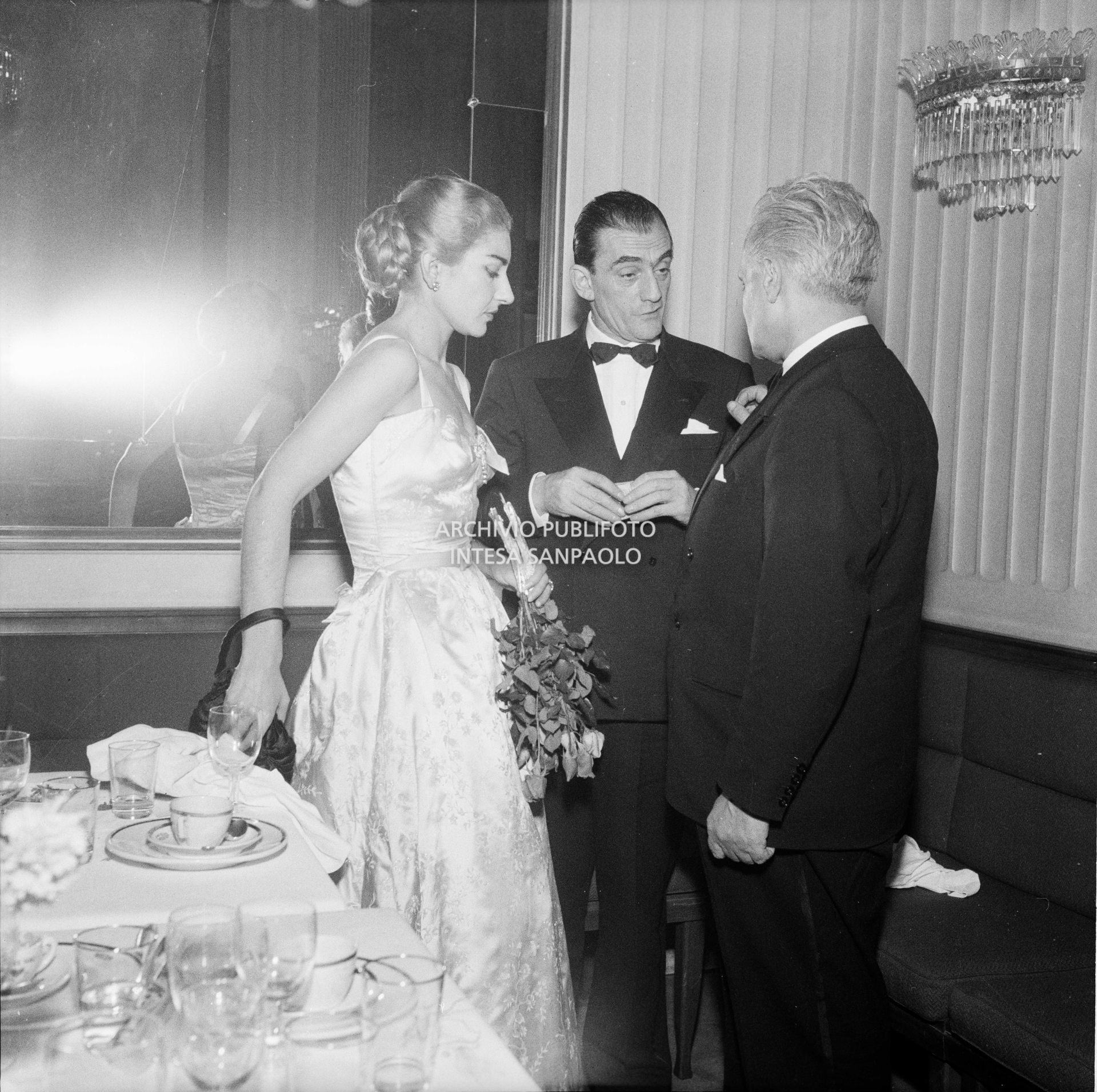 Maria Callas al ristorante Savini di Milano, la sera della Prima della Vestale di Gaspare Spontini, in compagnia del regista Luchino Visconti e del soprintendente del Teatro alla Scala Antonio Ghiringhelli