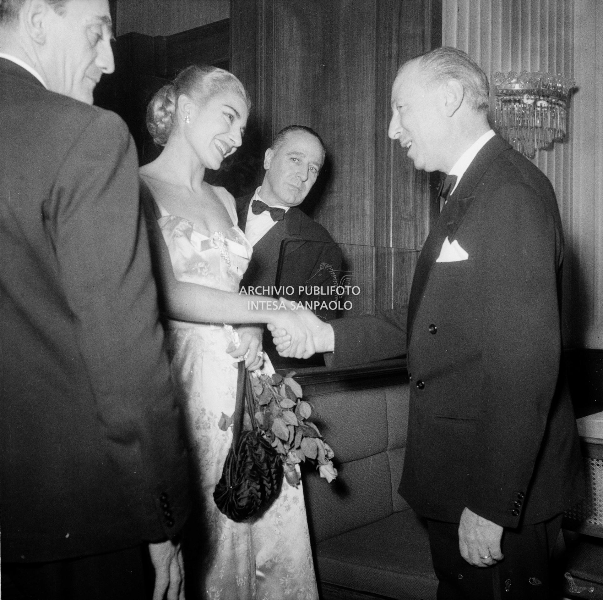 Maria Callas al ristorante Savini di Milano, la sera della Prima della Vestale di Gaspare Spontini; in primo piano a sinistra il regista Luchino Visconti