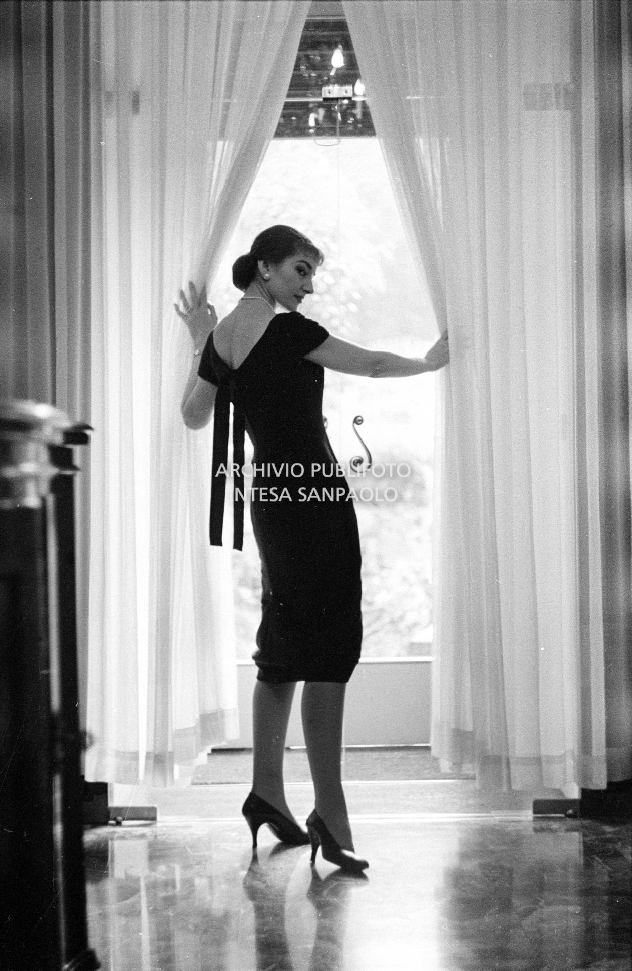 Maria Callas, ritratta nella sua abitazione, indossa un abito della sartoria Biki