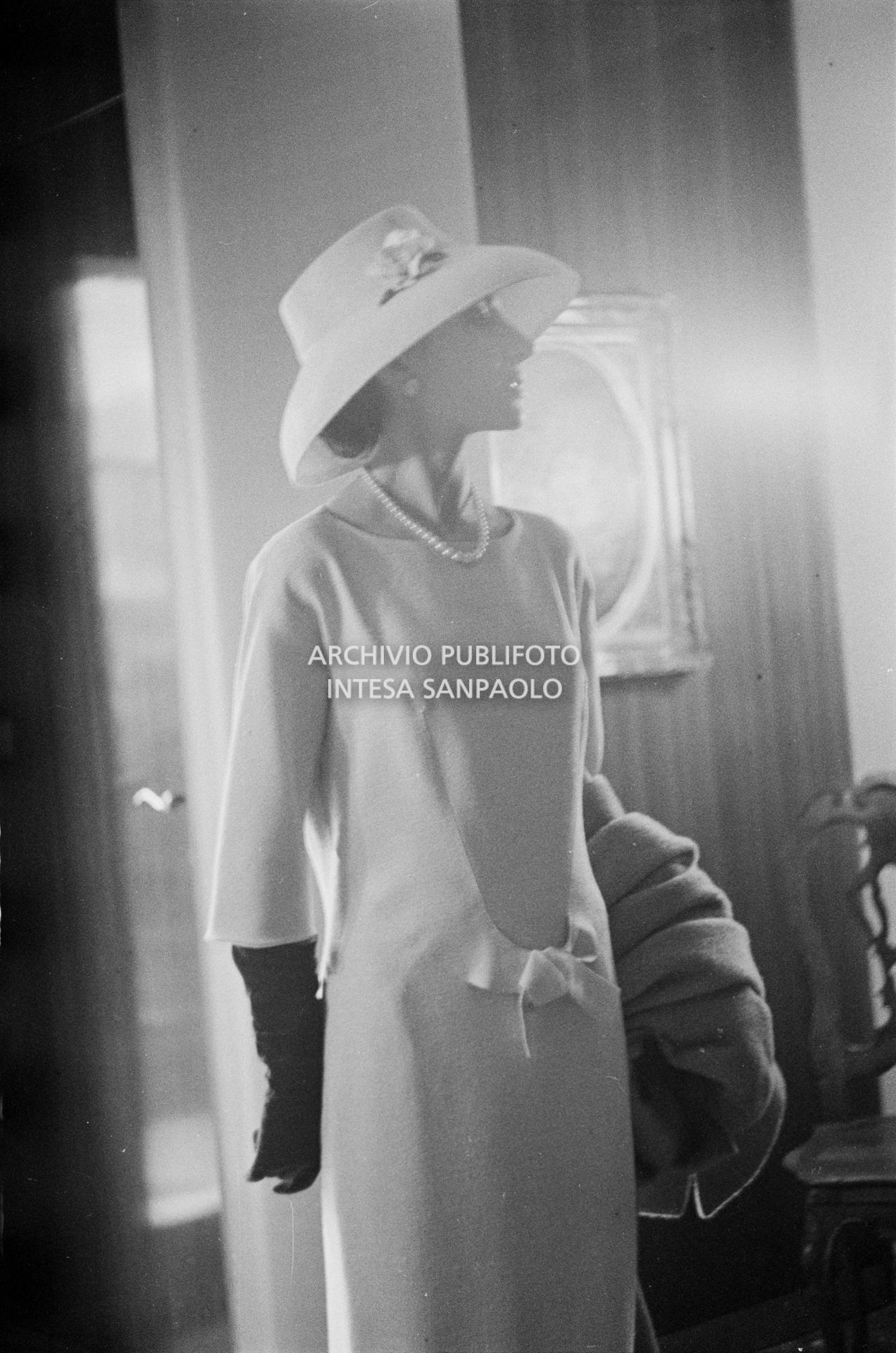 Maria Callas, ritratta nella sua abitazione, indossa abito e cappello della sartoria Biki