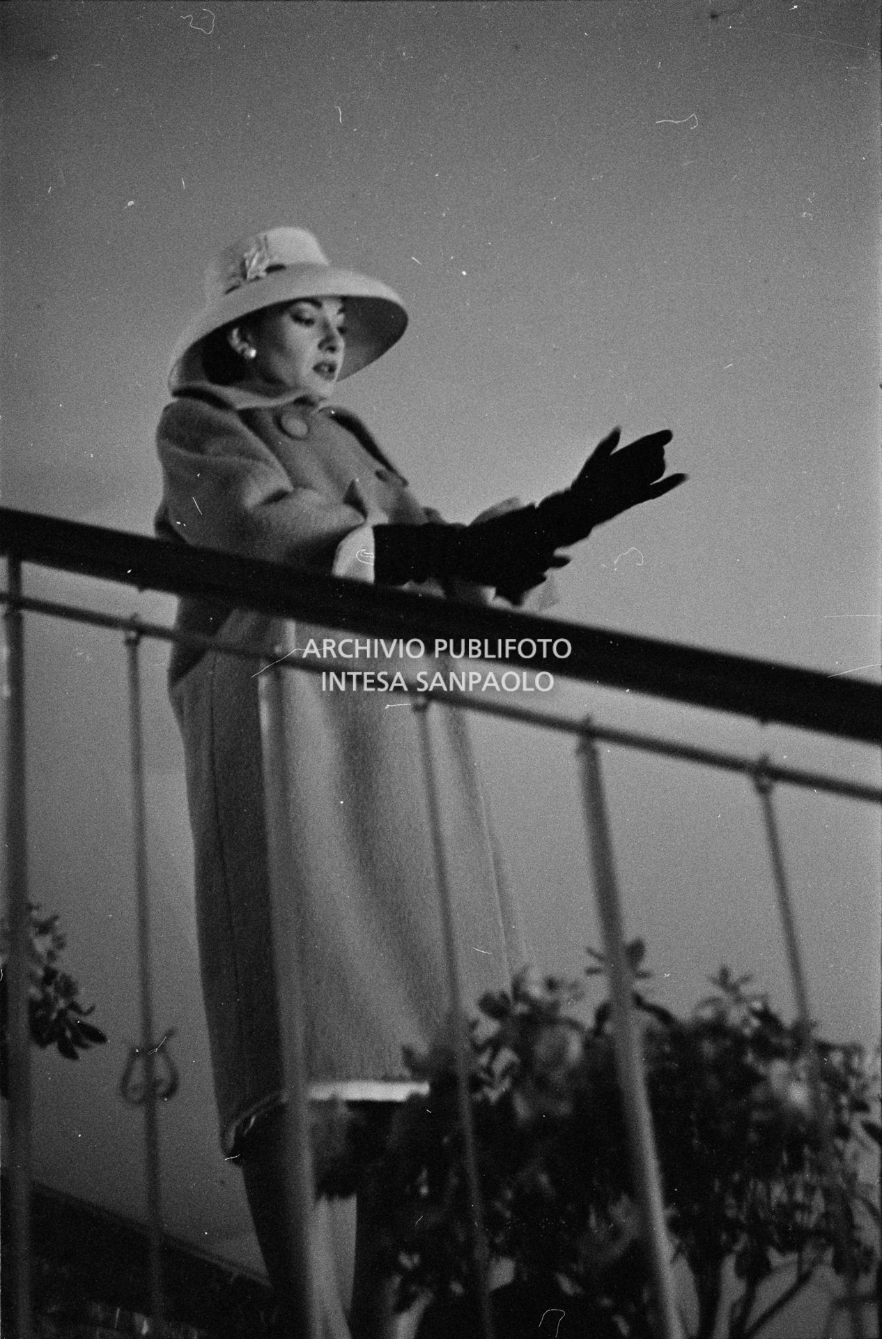 Maria Callas, ritratta in posa sulle scale della sua abitazione, indossa abito e cappello della sartoria Biki