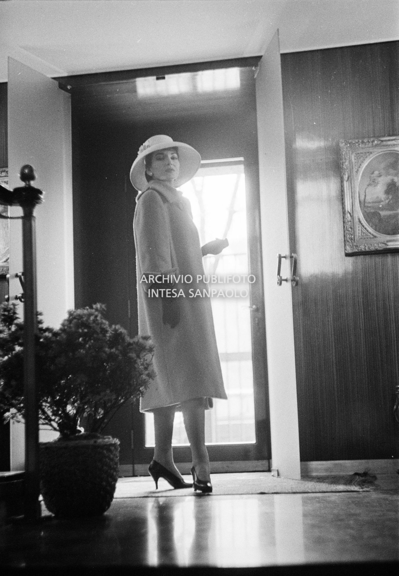 Maria Callas, ritratta in posa sulle scale della sua abitazione, indossa abito e cappello della sartoria Biki