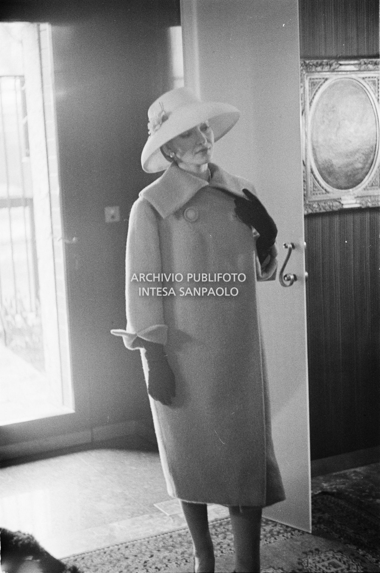 Maria Callas, ritratta in posa sulle scale della sua abitazione, indossa abito e cappello della sartoria Biki