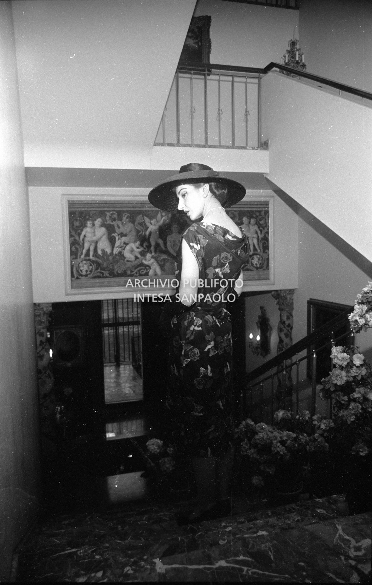 Maria Callas, ritratta nella sua abitazione, indossa abito e cappello della sartoria Biki