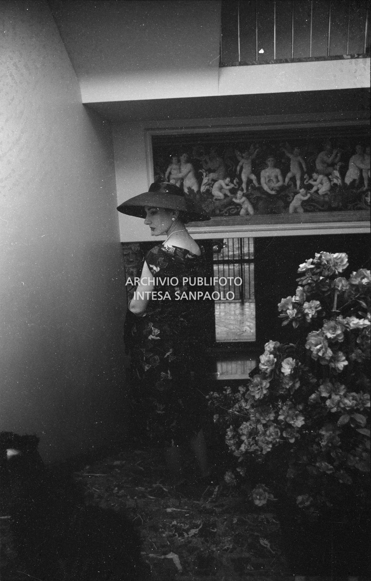 Maria Callas, ritratta nella sua abitazione, indossa abito e cappello della sartoria Biki