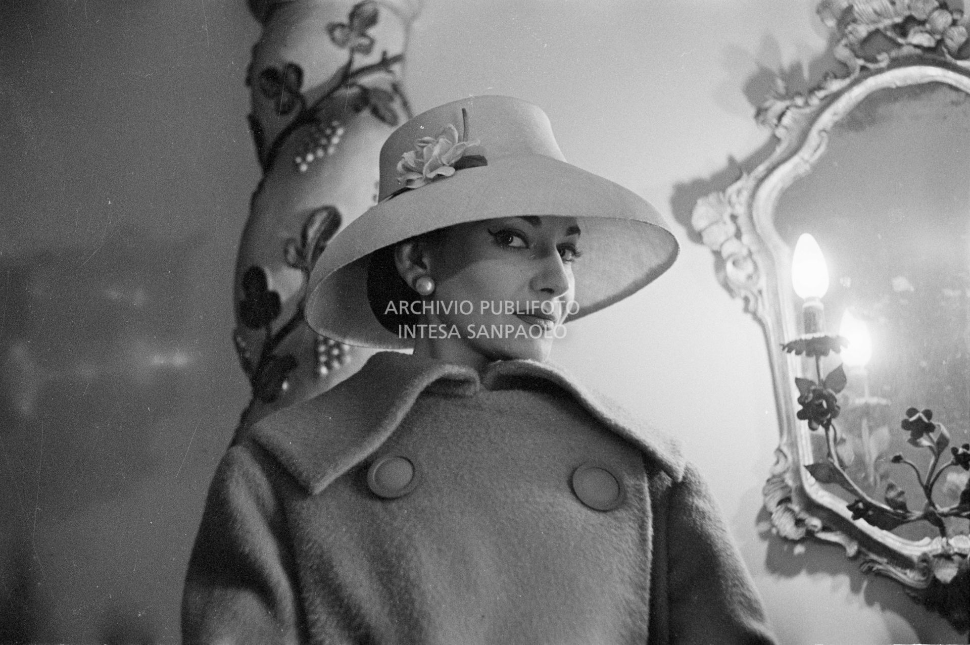 Maria Callas, ritratta nella sua abitazione, indossa abito e cappello della sartoria Biki