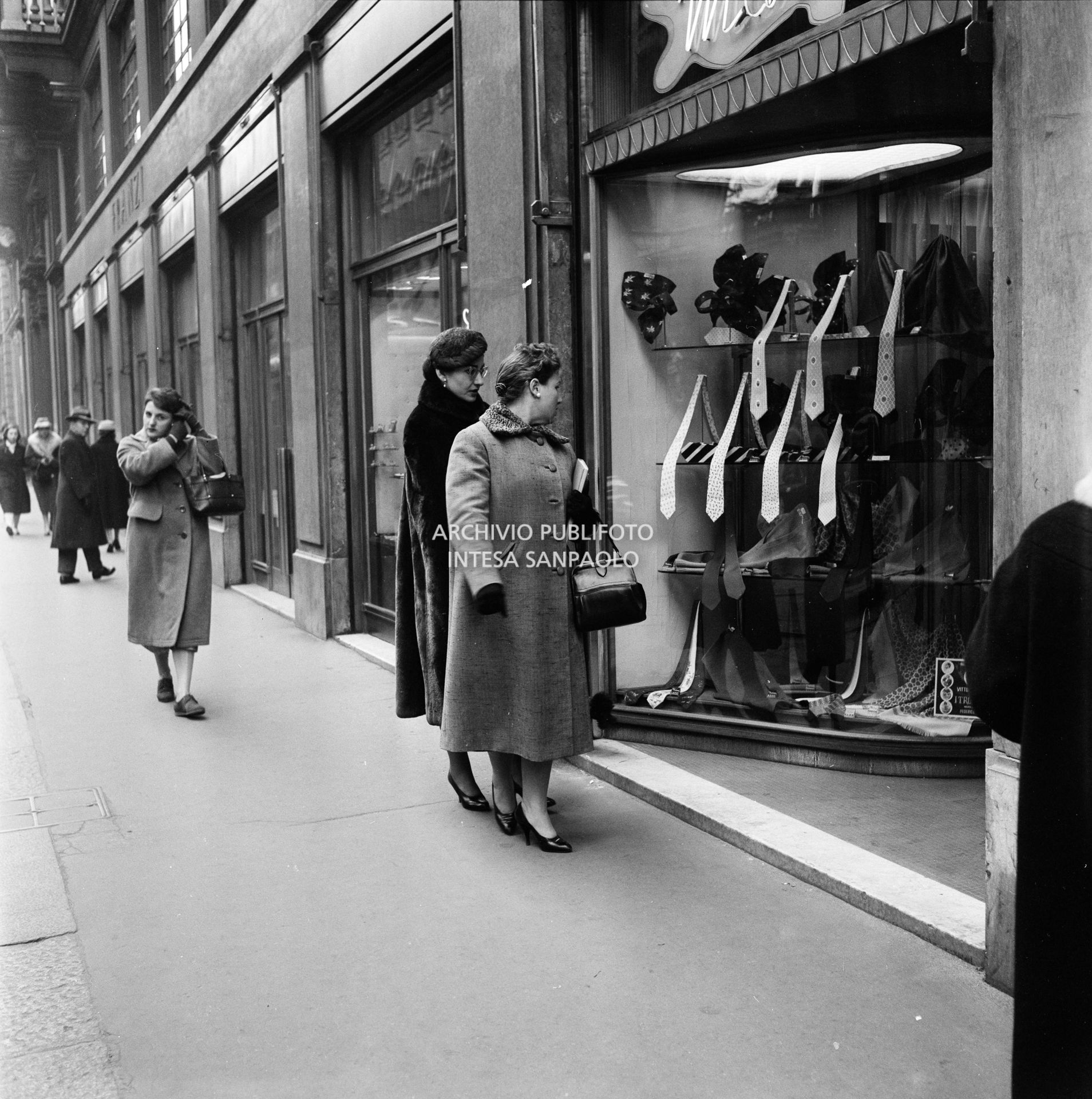 Maria Callas, con il suo barboncino, guarda una vetrina in via Manzoni a Milano in compagnia della sua segretaria