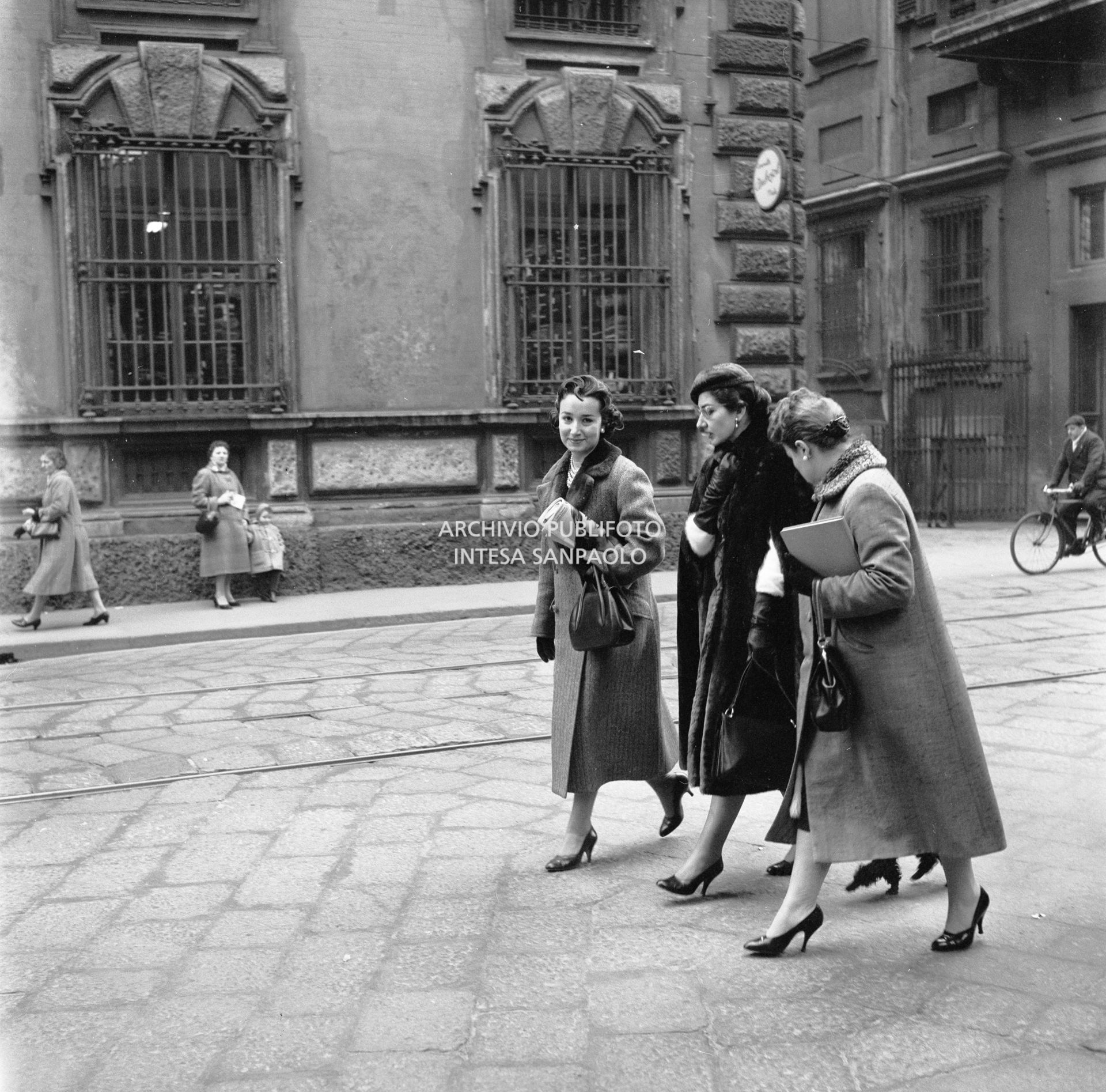 Maria Callas passeggia con il suo barboncino in compagnia dell'amica Giovanna Lomazzi, alla sua destra, e della sua segretaria, in via Manzoni a Milano