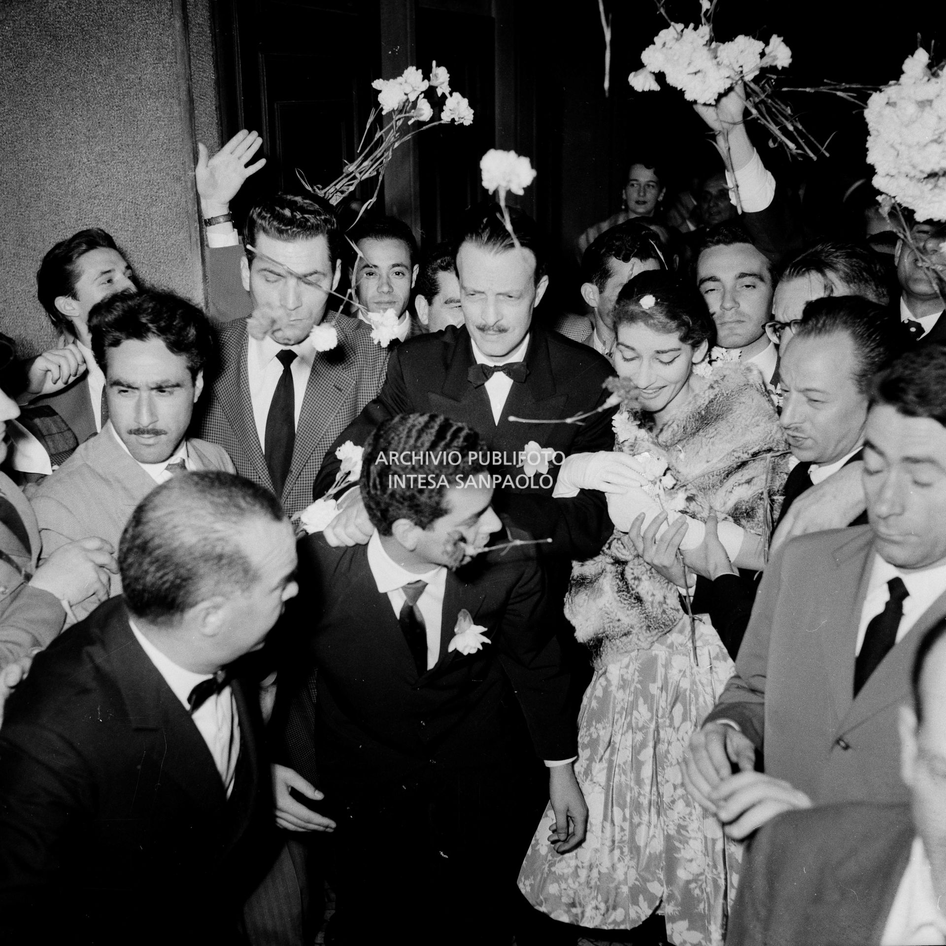 Maria Callas uscita dal Teatro alla Scala, dopo aver interpretato l'opera "Il pirata" di Vincenzo Bellini, si fa strada tra gli ammiratori entusiasti che le lanciano fiori