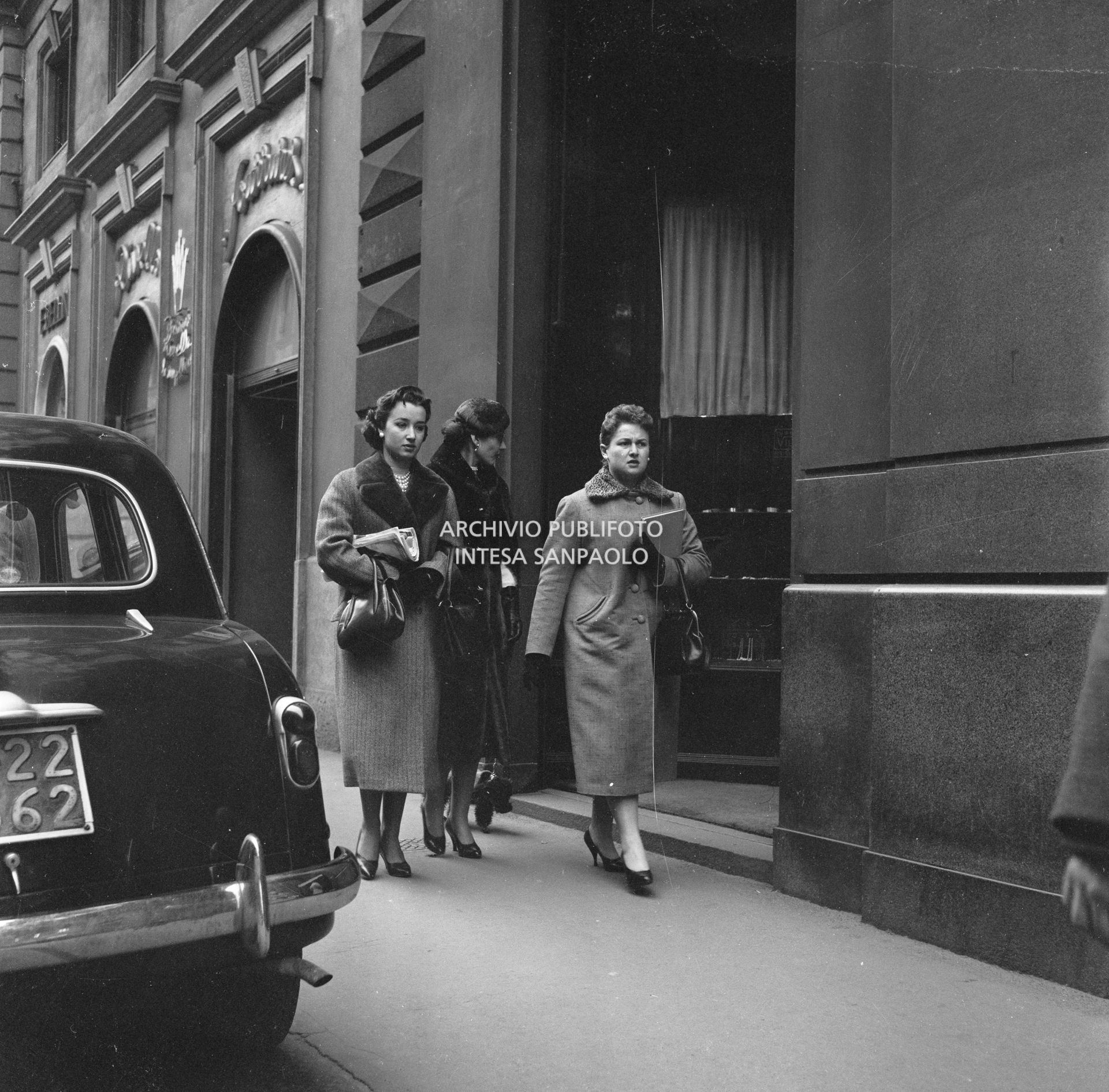 Maria Callas passeggia con il suo barboncino in compagnia dell'amica Giovanna Lomazzi, alla sua destra, e della sua segretaria, in via Manzoni a Milano