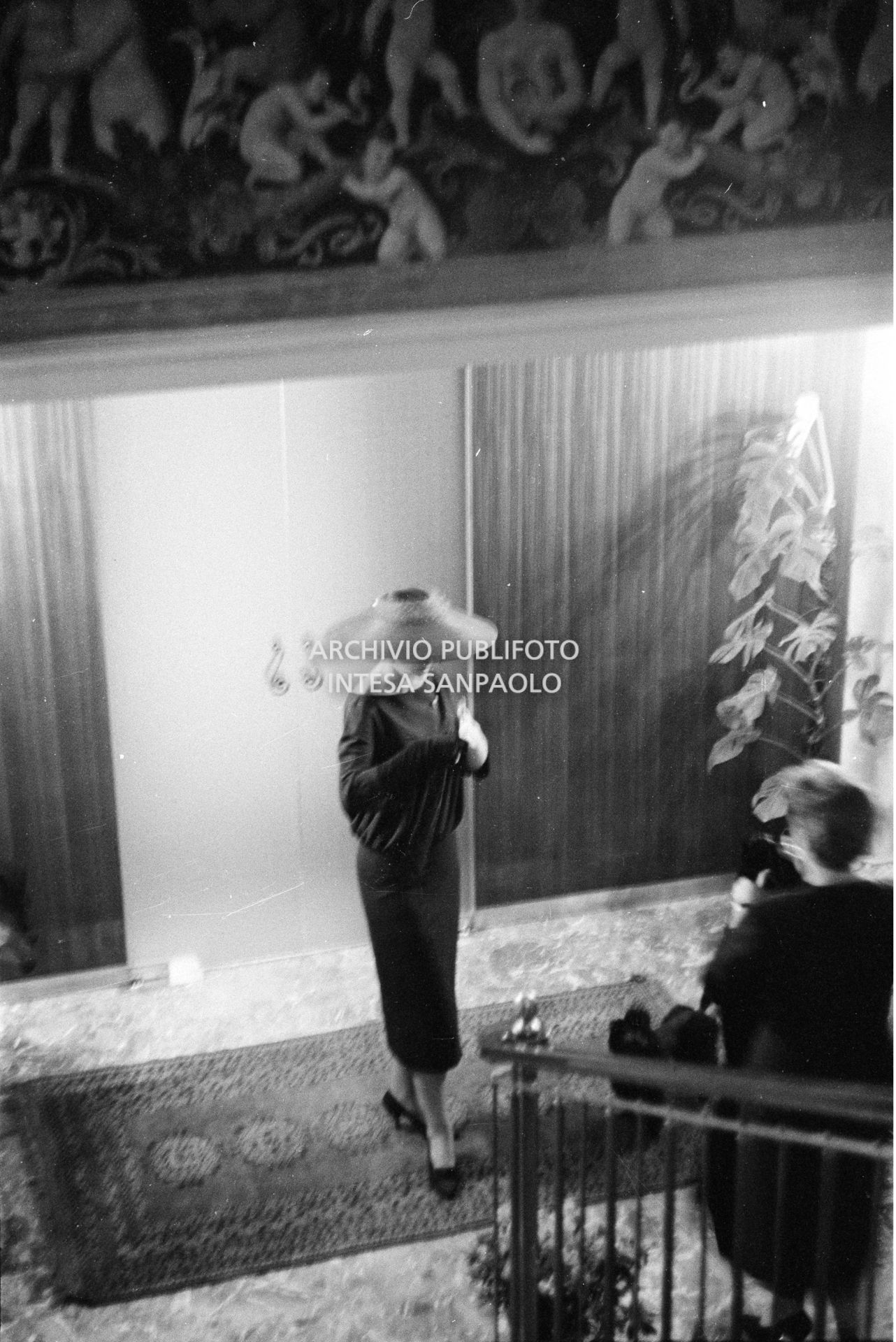 Maria Callas, ritratta nella sua abitazione, indossa un abito e un cappello della sartoria Biki