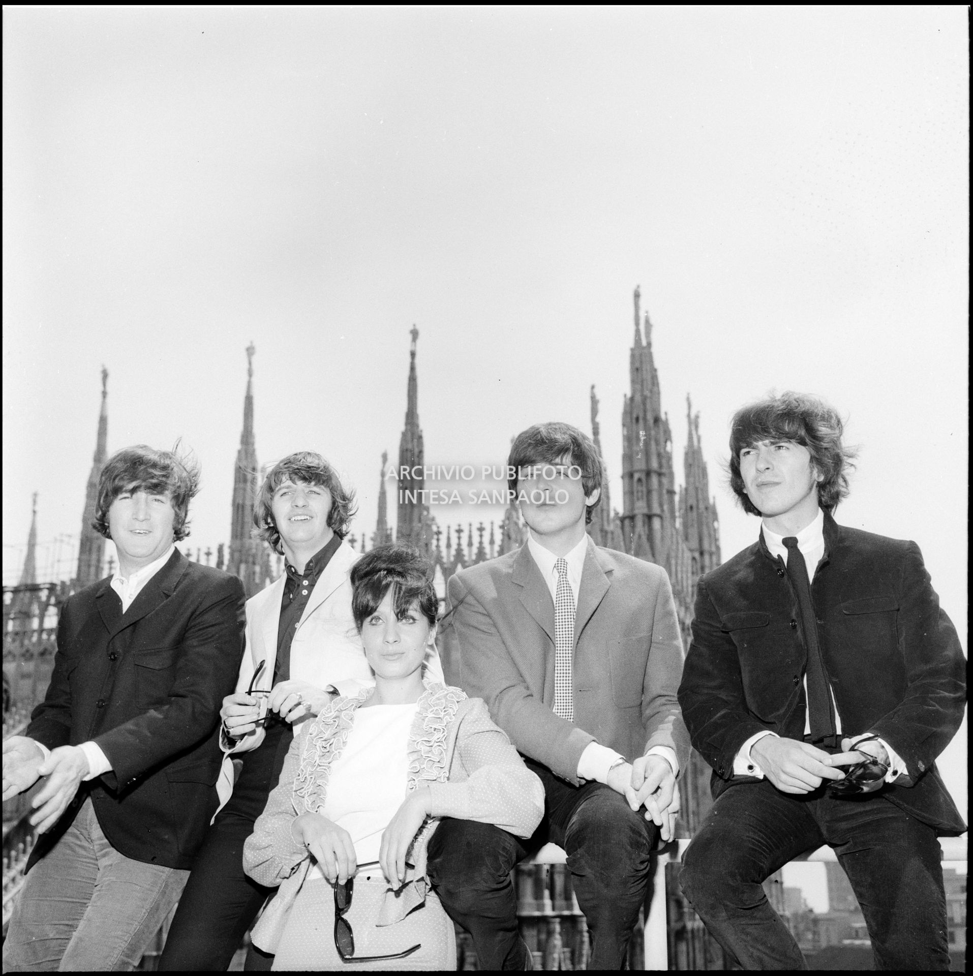 I Beatles con Rossella Como ritratti sulla terrazza del Grand Hotel Duomo a Milano; sullo sfondo le guglie della cattedrale