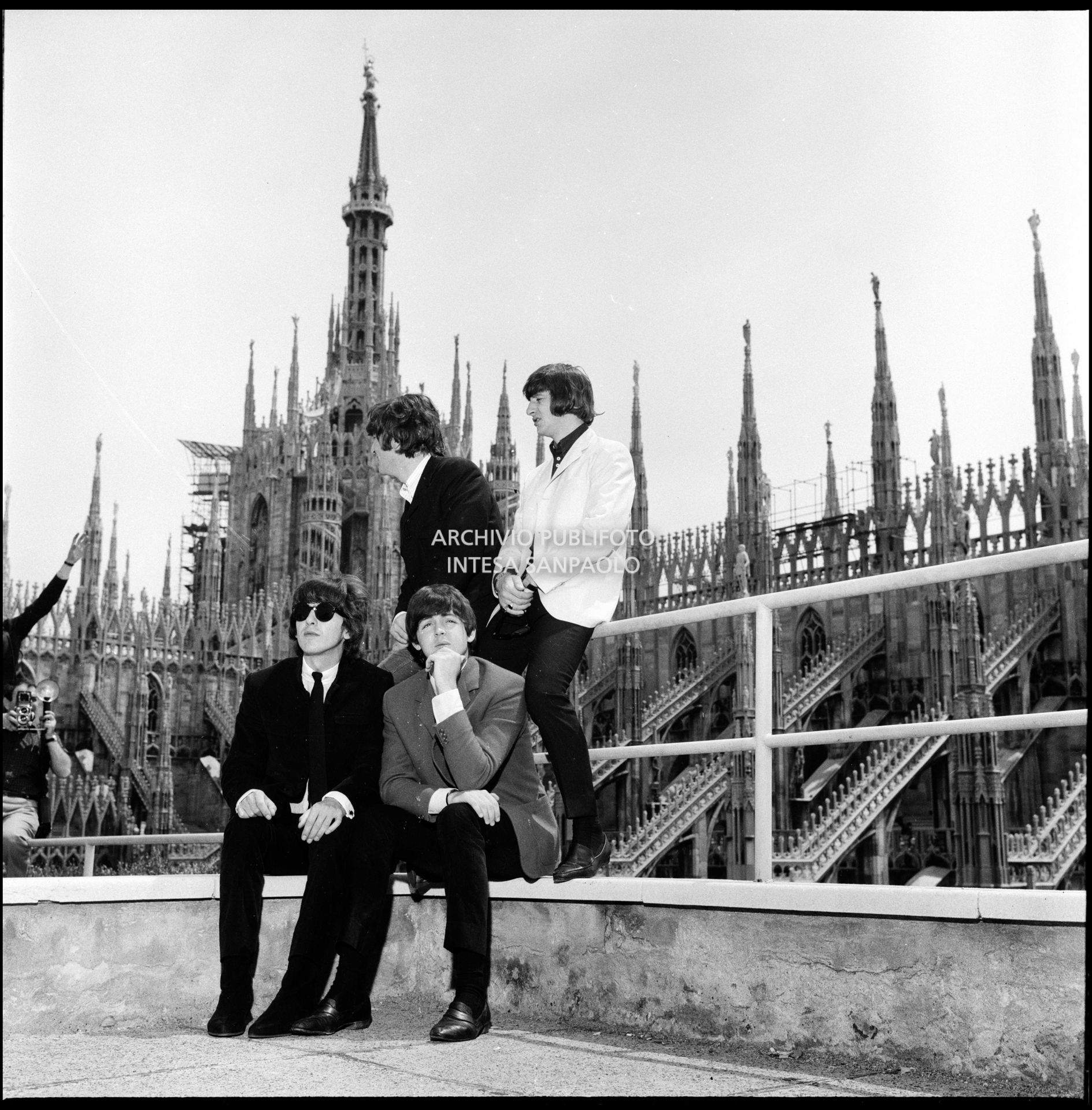 I Beatles ritratti sulla terrazza del Grand Hotel Duomo a Milano; sullo sfondo le guglie della cattedrale