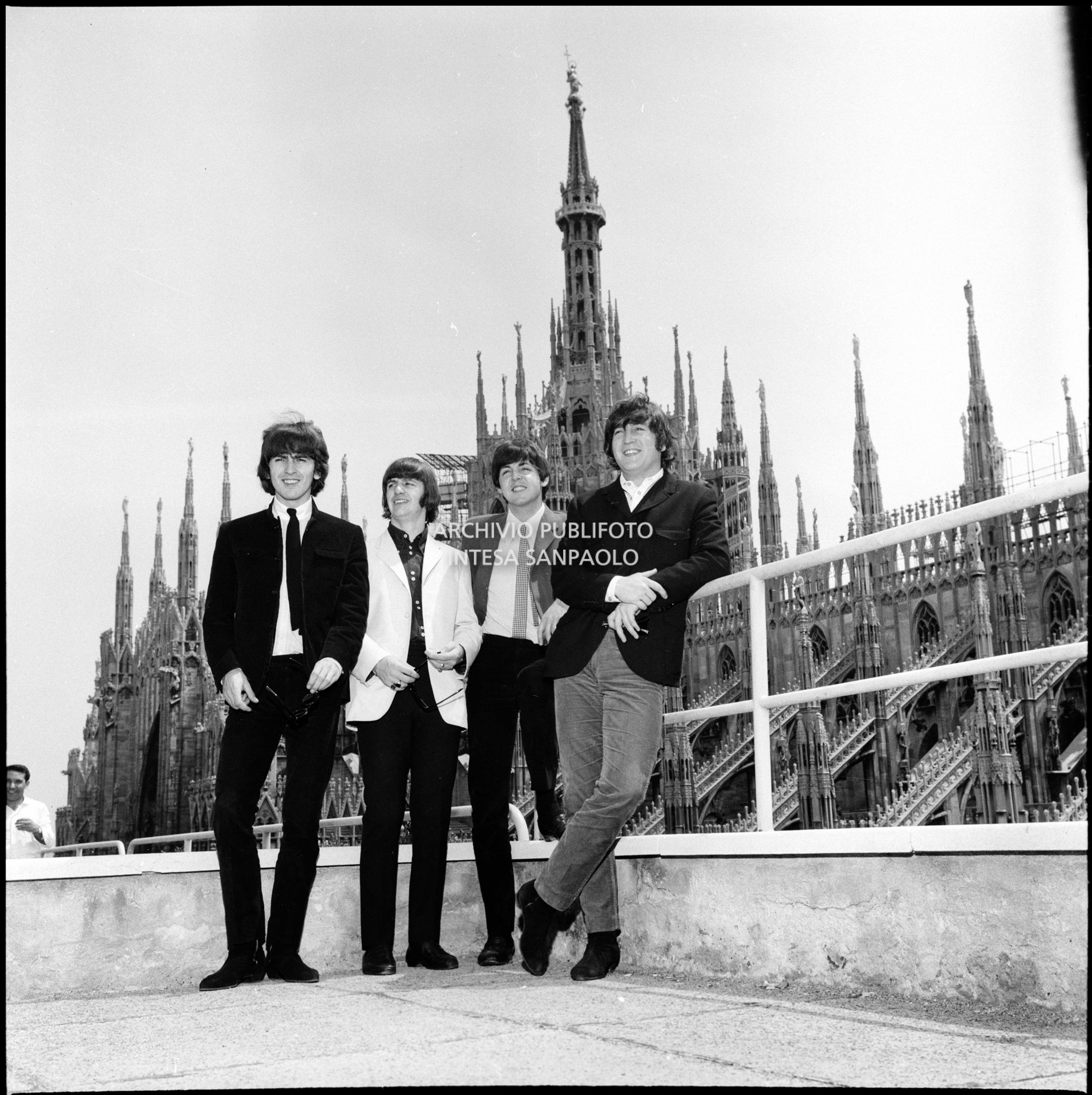 I Beatles ritratti sulla terrazza del Grand Hotel Duomo a Milano; sullo sfondo le guglie della cattedrale
